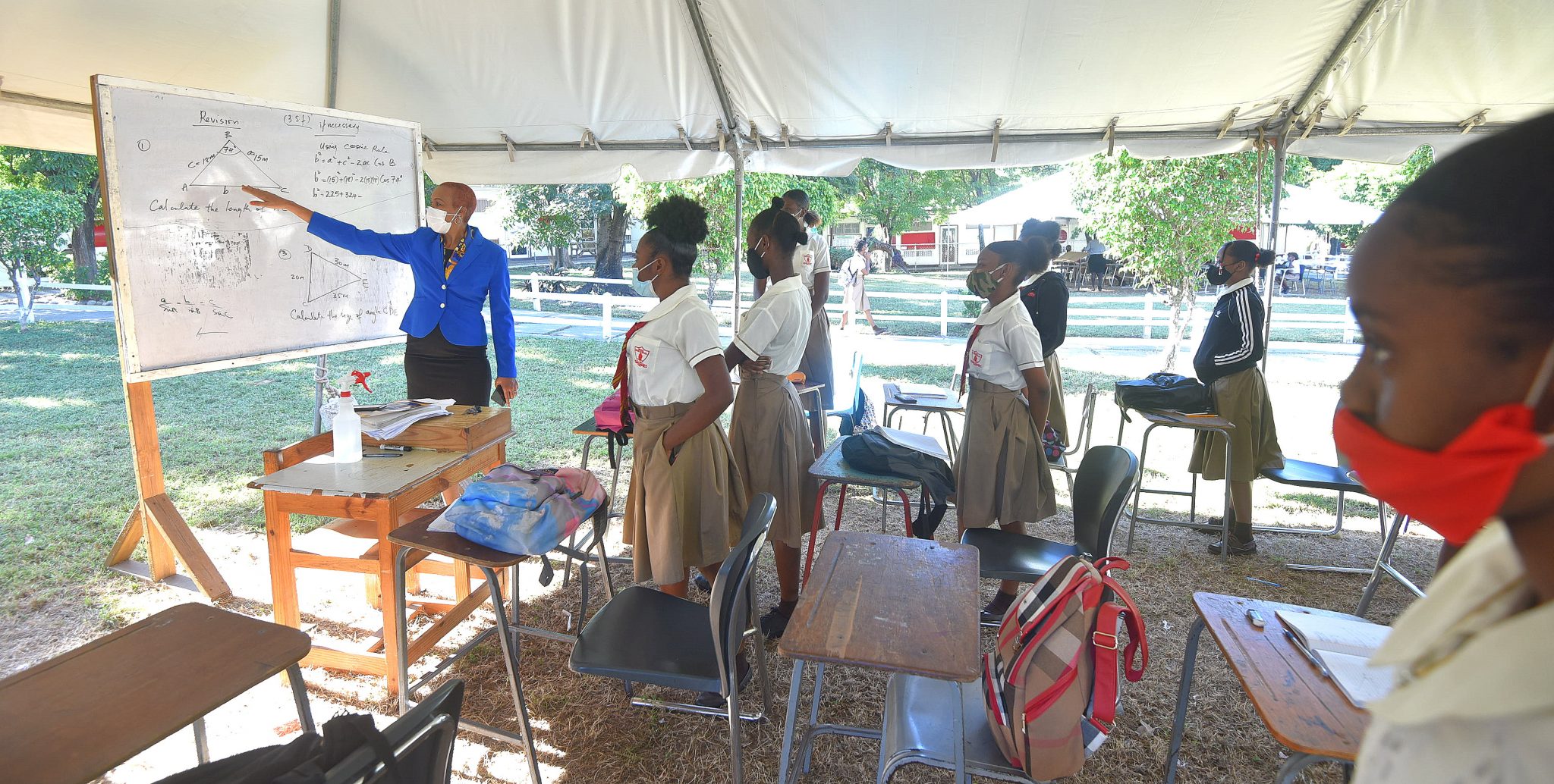 Minister of Education, Youth & Information, Hon. Fayval Williams (left, at board), interacts with Mona High School students in their outdoor classroom, during a tour of the institution on February 4.