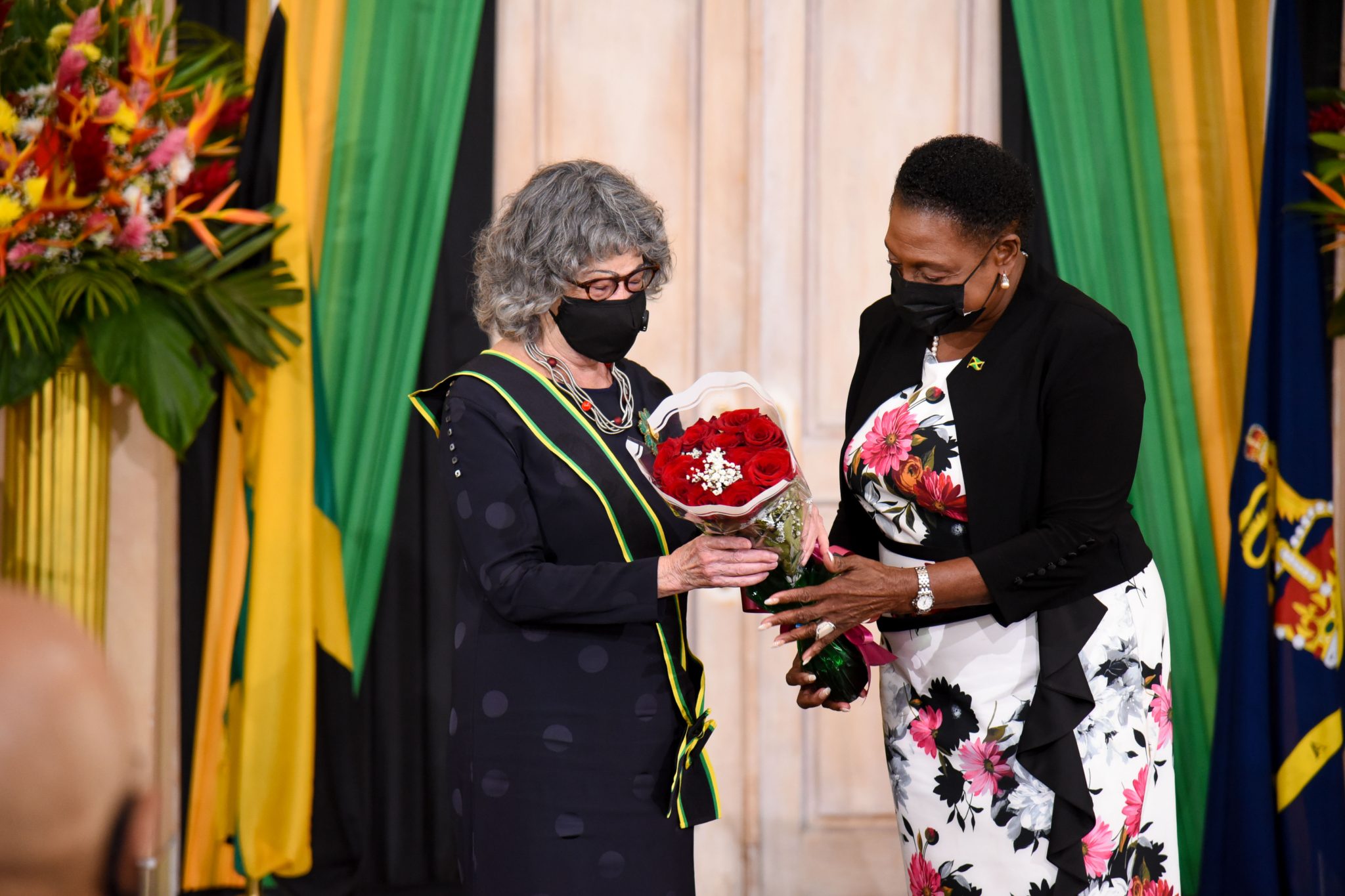 Minister of Culture, Gender, Entertainment and Sport, Hon. Olivia Grange (right) presents flowers to newly appointed Poet Laureate of Jamaica, Olive Senior, during the virtual investiture ceremony held recently at King's House.

