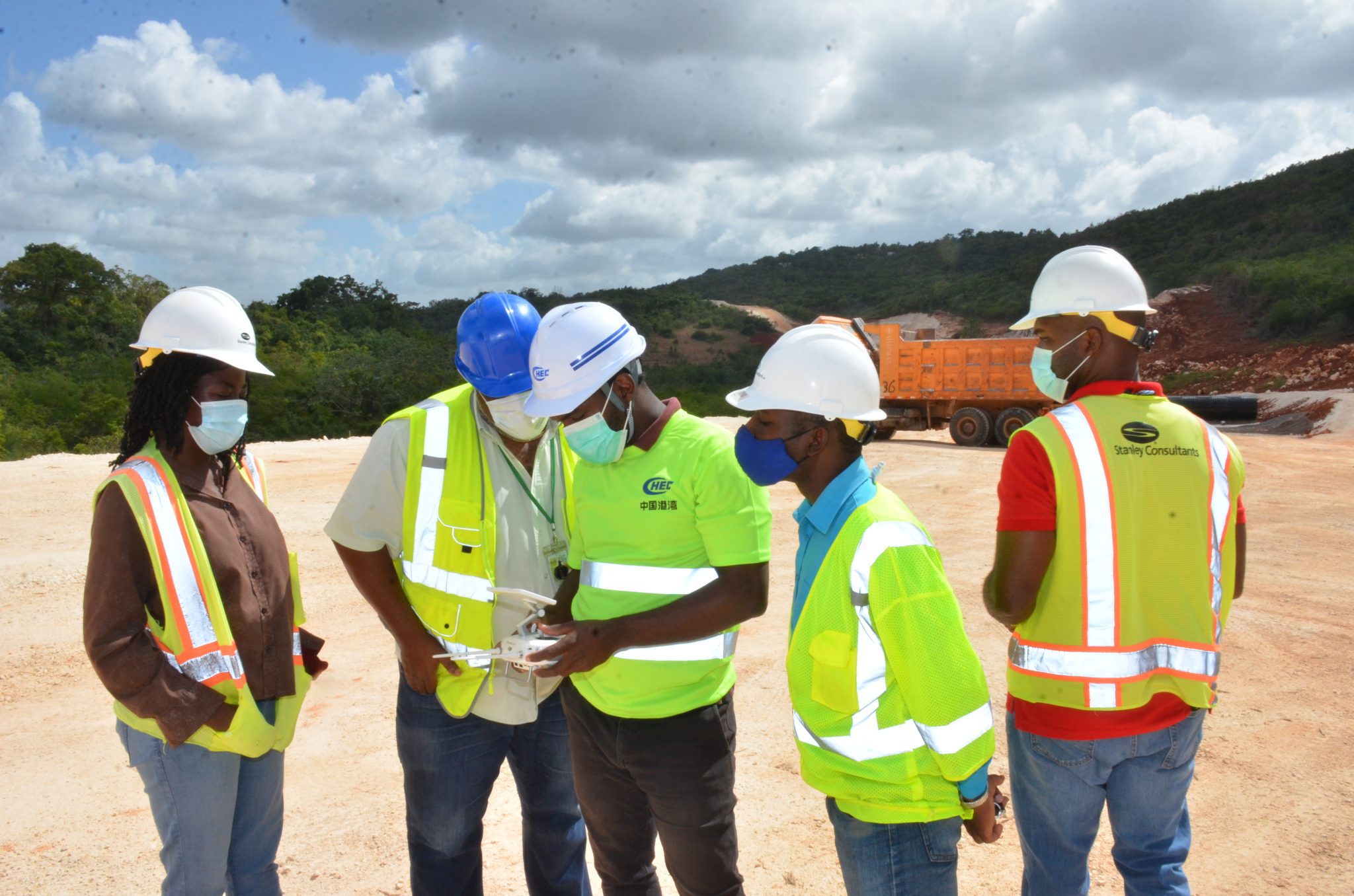 Senior Manager, Technical Services at the National Road Operating and Constructing Company, George Nicholson (second left);  Senior Construction Observer on Part A of the South Coast Highway Development Programme, Marcus Gray (right);  Junior Engineers Anna-Kaye French  (left) and Oshane Graham (second right), look at drone footage of the construction works on the May Pen to Williamsfield leg of Highway 2000 that was captured by JIS Drone Operator, Shamar Harris (centre), on a recent tour of the highway