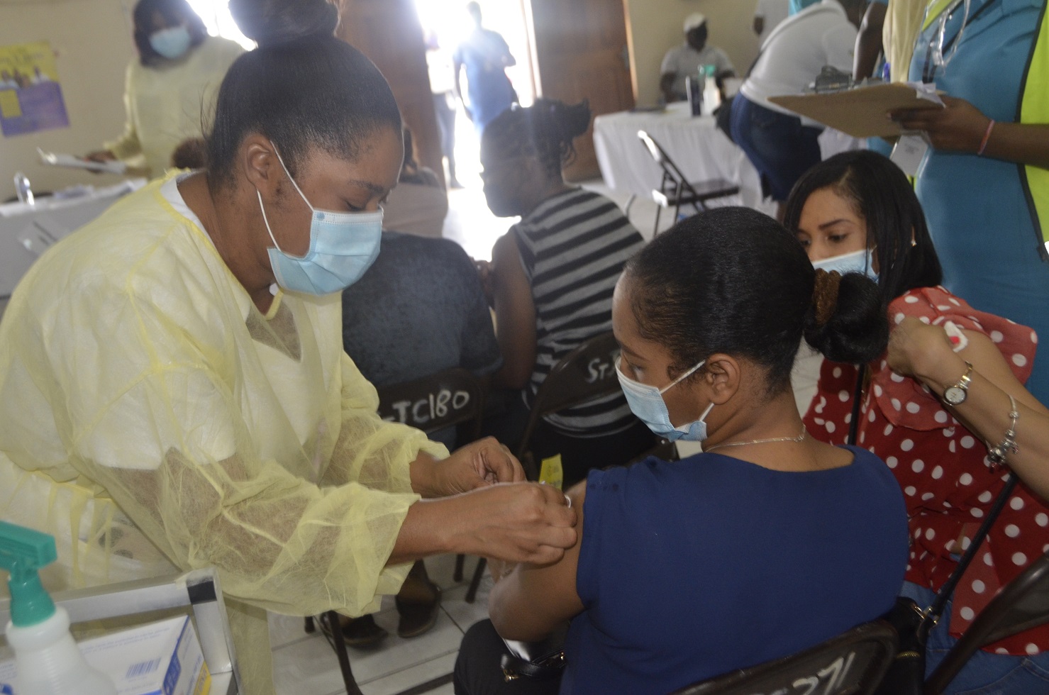 Midwife, Tenesha Smith (left), administers the AstraZeneca vaccine to 33-year-old Shatana Williams (centre) during a recent vaccination blitz at the Sean Lavery Faith Hall in Savanna-la-Mar, Westmoreland. Observing the process is 27-year-old teacher at Little London High in the parish, Moya Williams (right).