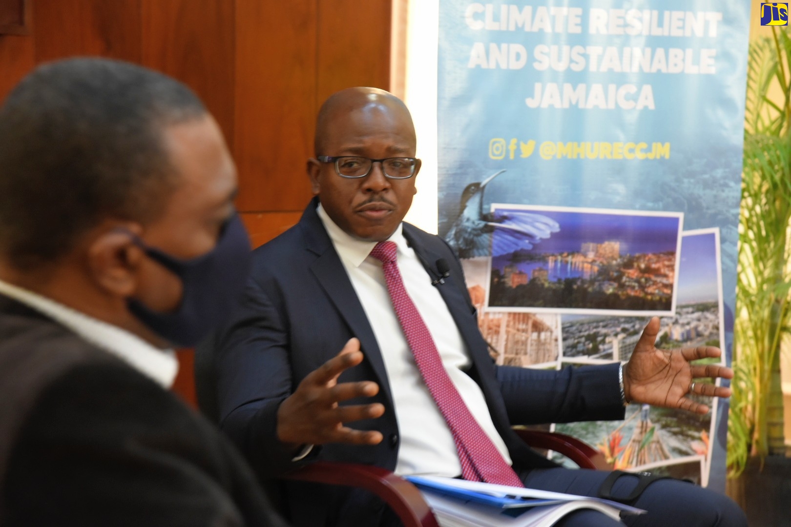 Minister of Housing, Urban Renewal, Environment and Climate Change, Hon. Pearnel Charles Jr (right), makes a point to General Manager of the Jamaica Mortgage Bank, Courtney Wynter, while addressing a virtual Town Hall on the draft National Housing Policy and Implementation Plan dubbed