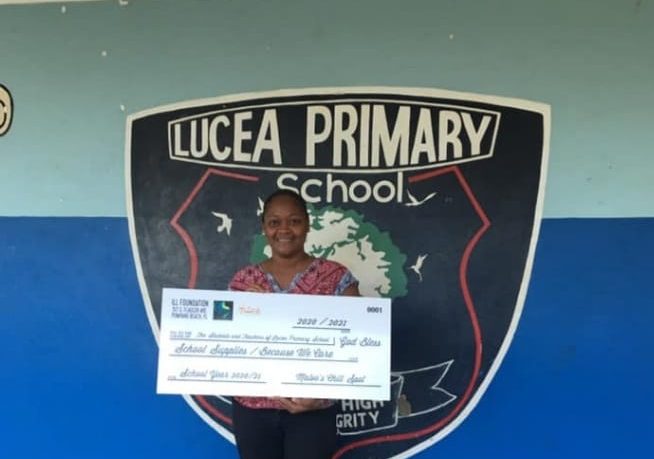 Principal of Lucea Primary School,. Yazmin Anderson Jackson,  displays the token cheque for stationery and other school supplies donated to the school by the I Love Lucea Foundation.