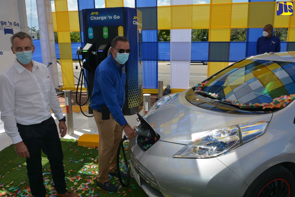 Minister of Science, Energy and Technology, Hon. Daryl Vaz (right), uses the first public electric vehicle charging station at the Boot Service Station in Drax Hall, St. Ann, during the commissioning of the facility on Friday (May 7). He is joined by President and Chief Executive Officer of Jamaica Public Service Company Limited (JPS), Michel Gantois.