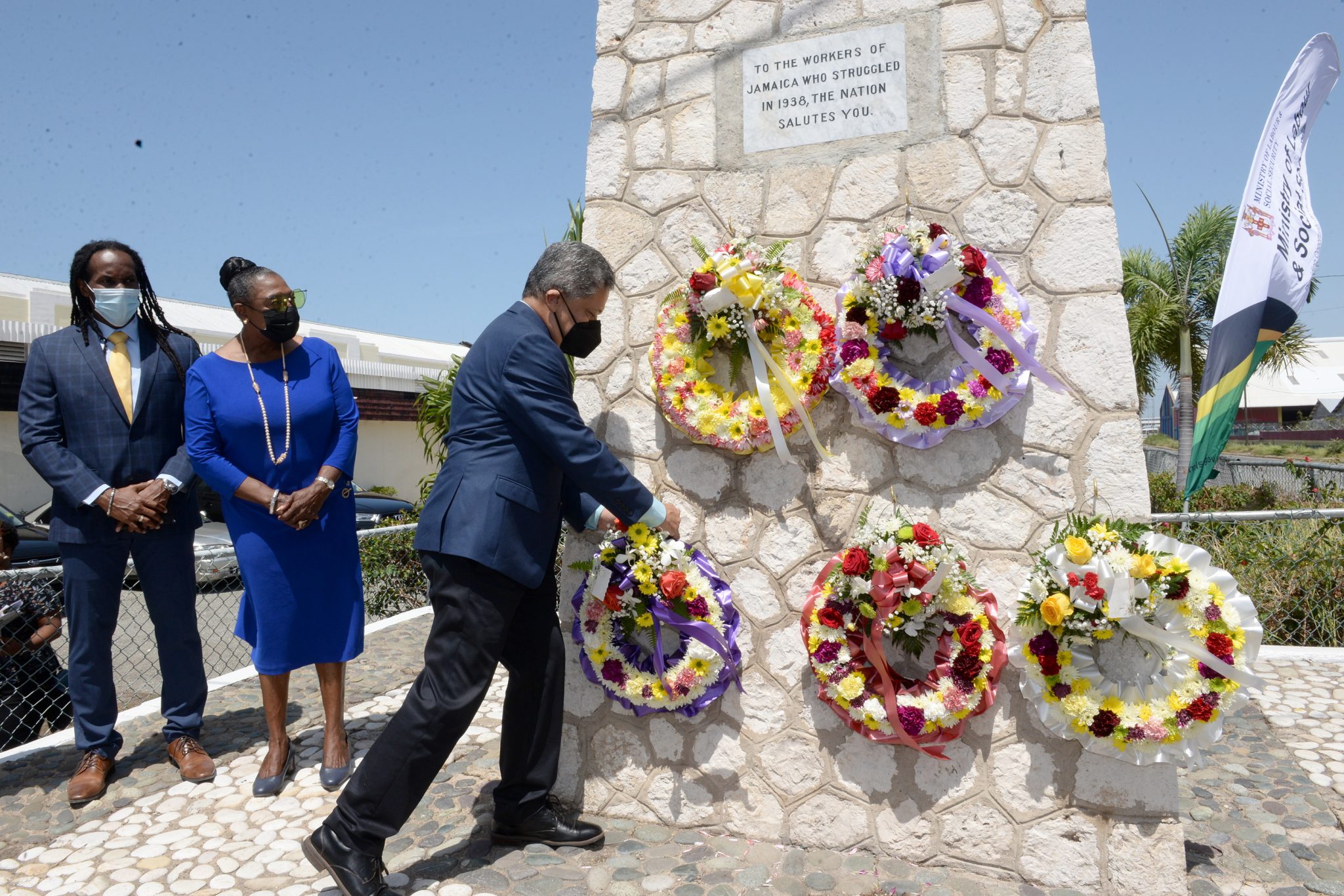 President of the Jamaica Employers’ Federation, David Wan (third left), places a wreath at the Aggie Bernard monument, Kingston Craft Market, downtown Kingston, on May 18, in recognition of National Workers Week/Labour Day. Workers Week is being observed under the theme ’Safeguarding our Labour Force amid COVID-19’, to pay tribute to the Jamaican workers who participated in the 1938 Labour Riots, which has led to improved working conditions for the workers of today.  Observing are Minister of Culture, Gender, Entertainment and Sport, Hon. Olivia Grange and State Minister in the Ministry,  Hon. Allando Terrelonge.

