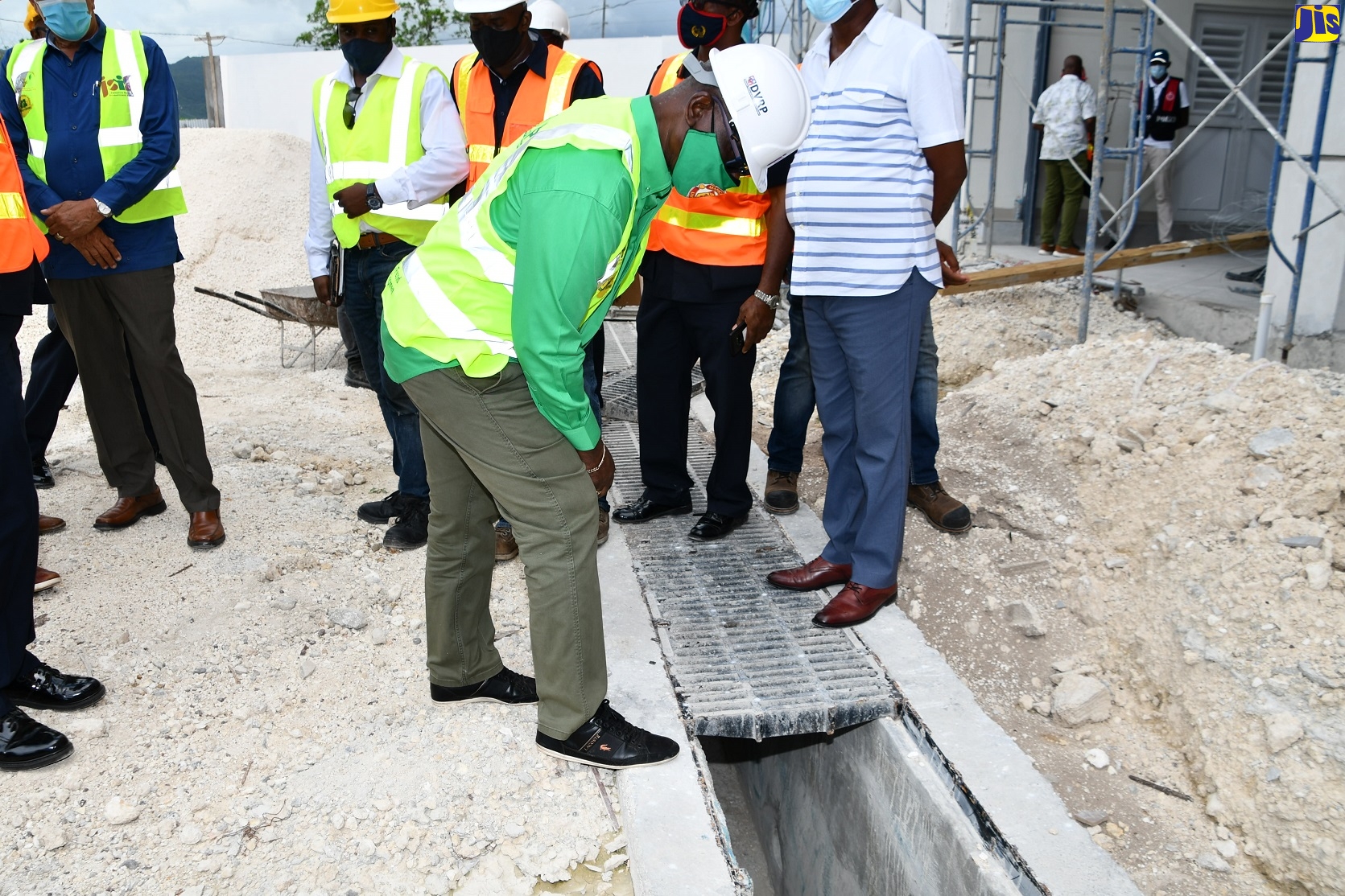 Minister of Local Government and Rural Development, Hon. Desmond McKenzie, examines a drain during a tour of the Barnett Street Fire Station construction project in Montego Bay, St. James, on Friday (June 25).