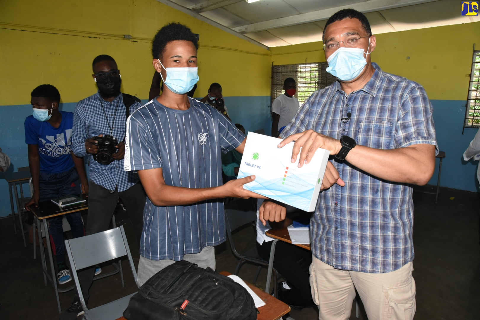 Prime Minister, the Most Hon. Andrew Holness (right), presents Penwood High School Grade 11 student, Ricardo McIntosh, with a tablet computer. Prime Minister Holness was visiting students who participated in special ‘super classes’ facilitated at the institution on Saturday (June 26) by the non-profit organisation, Jamaica Millennium Vision for Youth (JMVY), for 2021 Caribbean Secondary Education Certificate (CSEC) and Caribbean Advanced Proficiency Examination (CAPE) external test candidates.