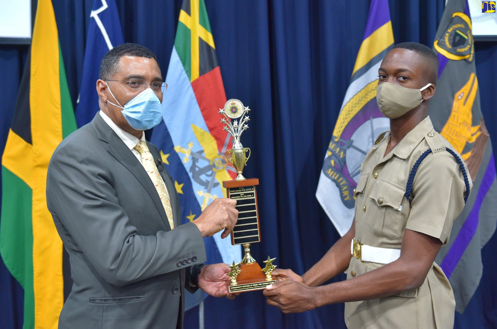 Prime Minister, the Most Hon. Andrew Holness (left), presents Private (NS) Orrington Harvey with the runner-up trophy for the Jamaica Defence Force (JDF) Commandant