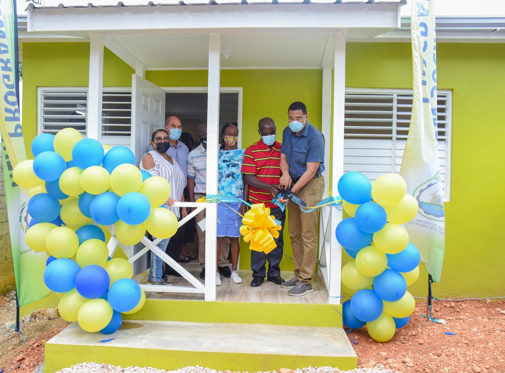 Prime Minister, the Most Hon. Andrew Holness (right) cuts the ribbon to officially hand over a new three-bedroom dwelling to Byron Reid (2nd right) and his common-law wife Zelda Jacobs (3rd right) , in Albert Town, Trelawny  on Friday (July 2). Sharing in the moment (from left) are Member of Parliament for Southern Trelawny, Marisa Dalrymple-Philibert; Custos of Trelawny, Hugh Gentles; and Mayor of Falmouth, Councillor Colin Gager (partially hidden).