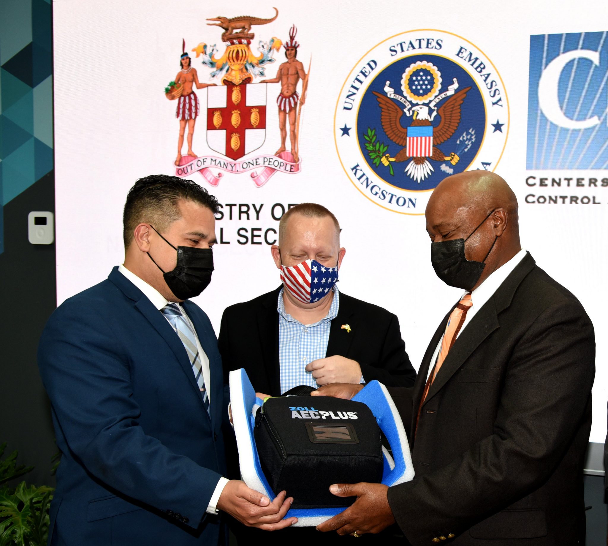 Minister without portfolio in the Ministry of National Security, Senator the Hon. Matthew Samuda (left) and Commissioner of Corrections, Lieutenant Colonel (Ret’d) Gary Rowe (right), look at a piece of medical equipment, which was among medical and sanitation items donated to the Department of Correctional Services (DCS) by the United States (US) Centers for Disease Control and Prevention Caribbean Regional Office. Looking on is Chargé d