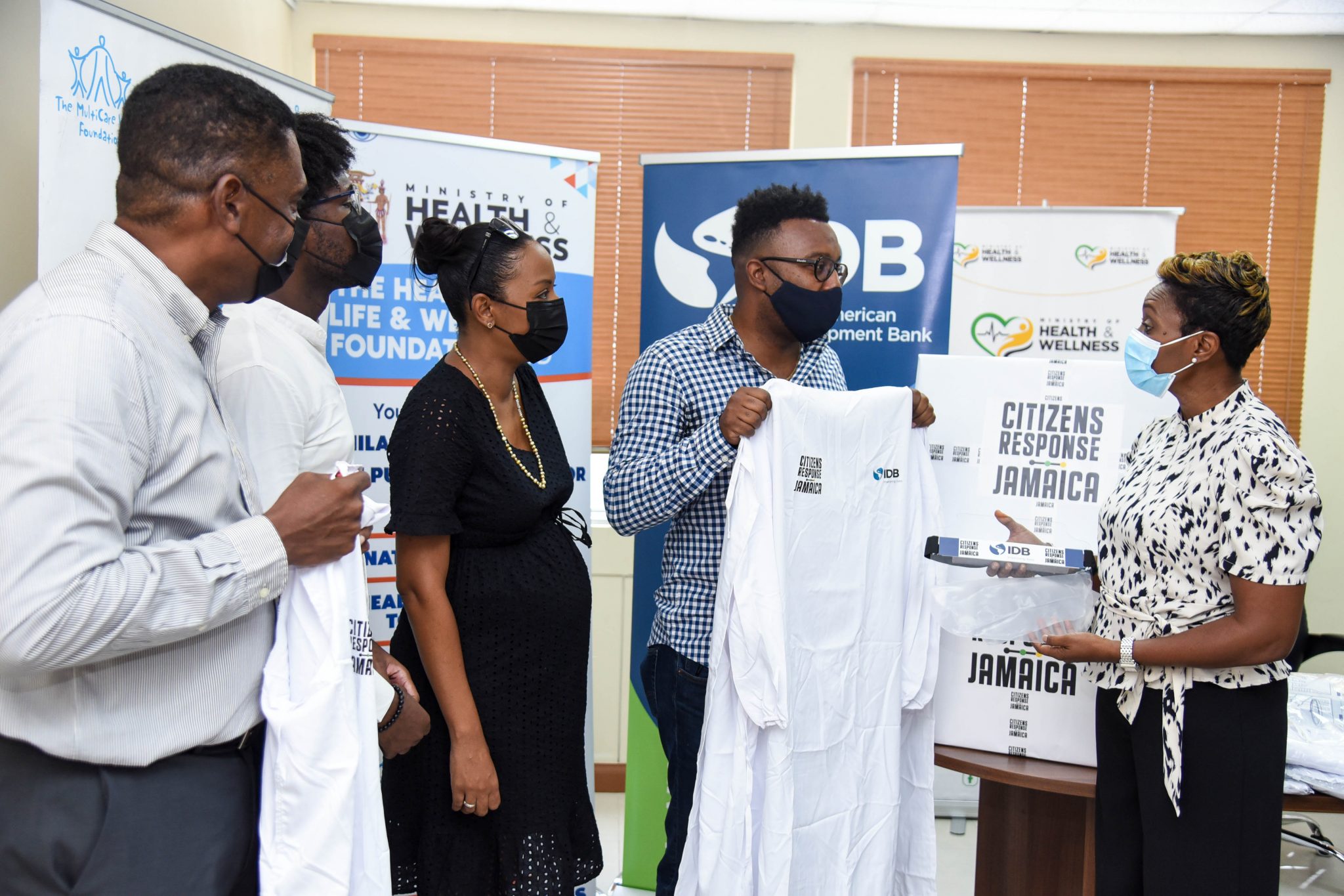 State Minister, Ministry of Health and Wellness, Juliet Cuthbert Flynn (right), is presented with medical isolation gowns by Founder of local non-profit organisation, Citizens Response JA (CRJA), Larren Peart (second right), during the handover of personal protective equipment (PPE) at the Ministry’s New Kingston Offices on Monday (July 5). Looking on are (from left) Executive Director of the Ministry’s Health for Life and Wellness Foundation, Courtney Cephas; Marketing and Communications Officer, MultiCare Youth Foundation, Chandapaul Brown; and Executive Director, Multicare Youth Foundation, Alicia Glasgow Gentles.