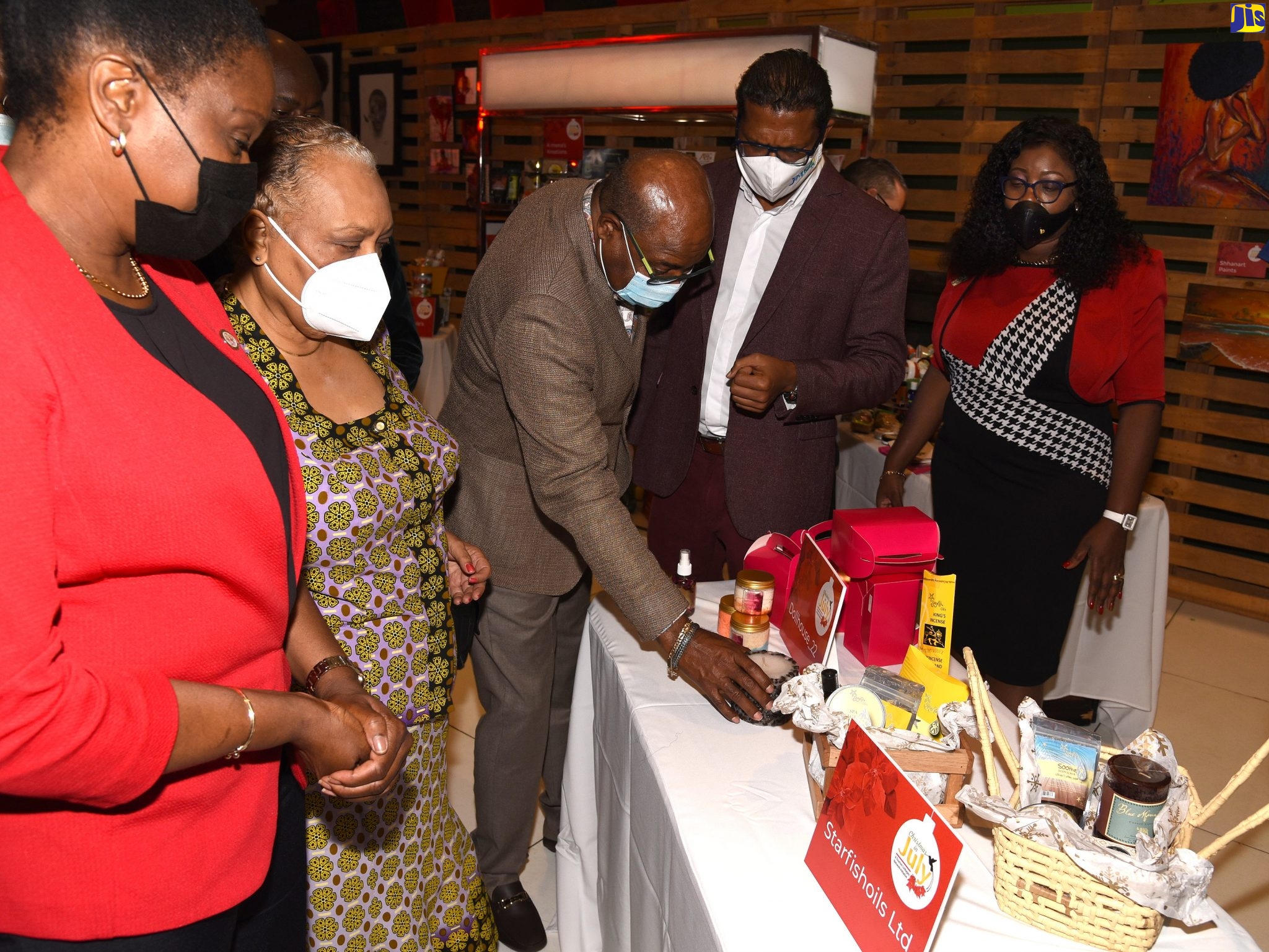 Tourism Minister, Hon. Edmund Bartlett (centre), views products on display during the seventh ‘Christmas in July’ tradeshow at the Jamaica Pegasus Hotel in New Kingston, following the opening ceremony on Thursday (July 22). Others (from left) are: Permanent Secretary in the Tourism Ministry, Jennifer Griffith; Chief Executive Officer, Jamaica Business Development Corporation (JBDC), Valerie Veira; Chairman, Manufacturing Technical Working Group, Tourism Linkages Council, Richard Pandohie; and Director, Tourism Linkages Network, Carolyn McDonald-Riley.