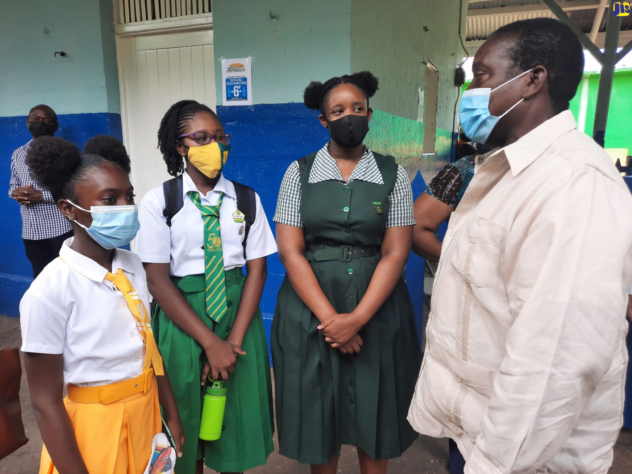 Minister of Transport and Mining, Hon. Robert Montague (right), engages with students from St. Catherine schools, who participated in the Ministry’s final test run of the school train service, which is scheduled to begin in September. The students are (from left to right): Rachel Duncan of McAuley Primary; Ruth Reid of Old Harbour High; and Gabrielle Christian of St. Jago High.