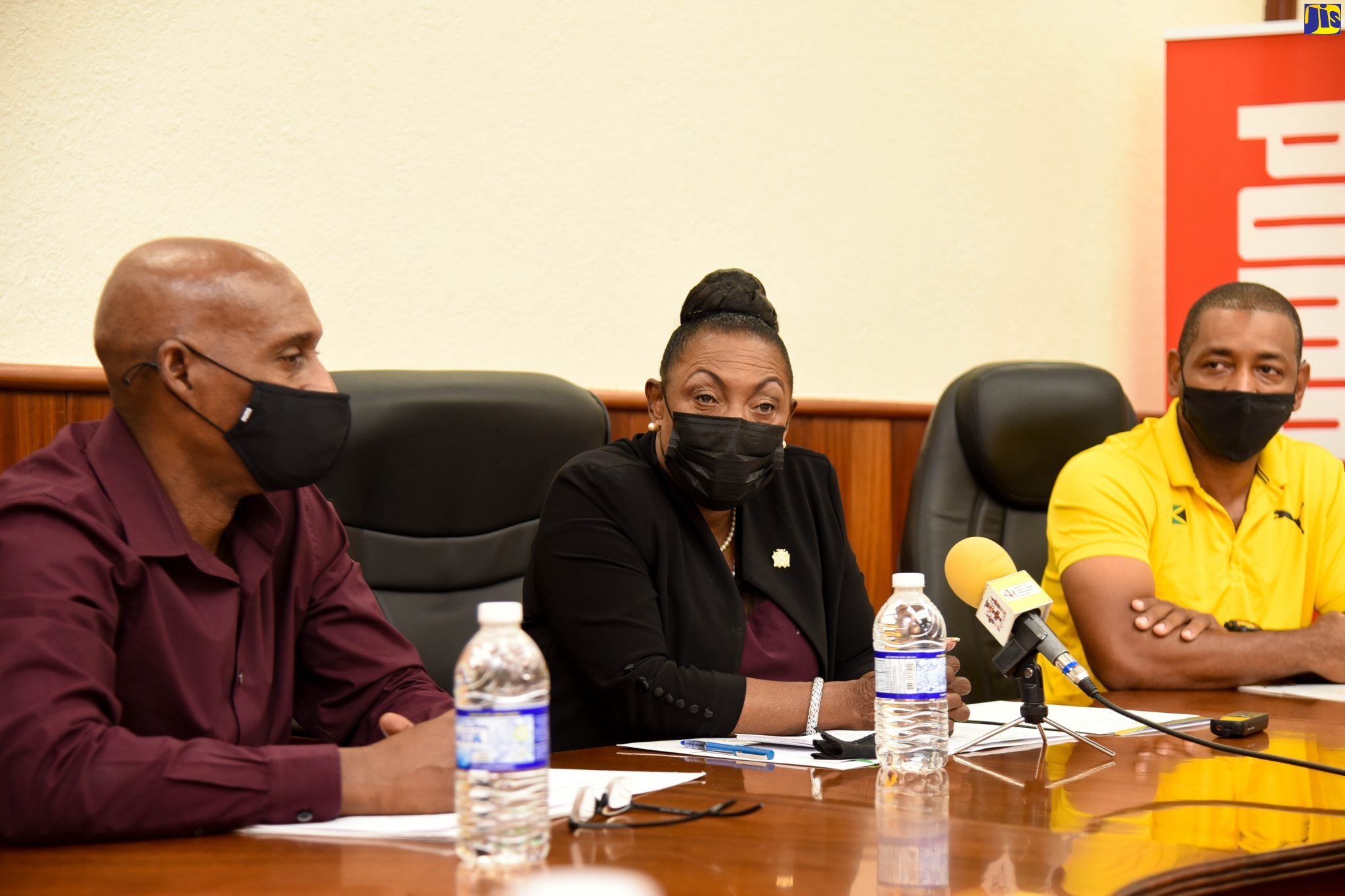 Minister of Culture, Gender, Entertainment and Sport, Hon. Olivia Grange (centre), speaking during a send-off ceremony held at the Jamaica Athletics Administrative Association (JAAA) in Kingston on Thursday (August 12) for athletes representing Jamaica at the World Athletics Under 20 Championships from August 17 to 22 in Nairobi, Kenya. She is flanked by JAAA President, Garth Gayle (left), and Technical Leader for the management team for the games, David Riley.