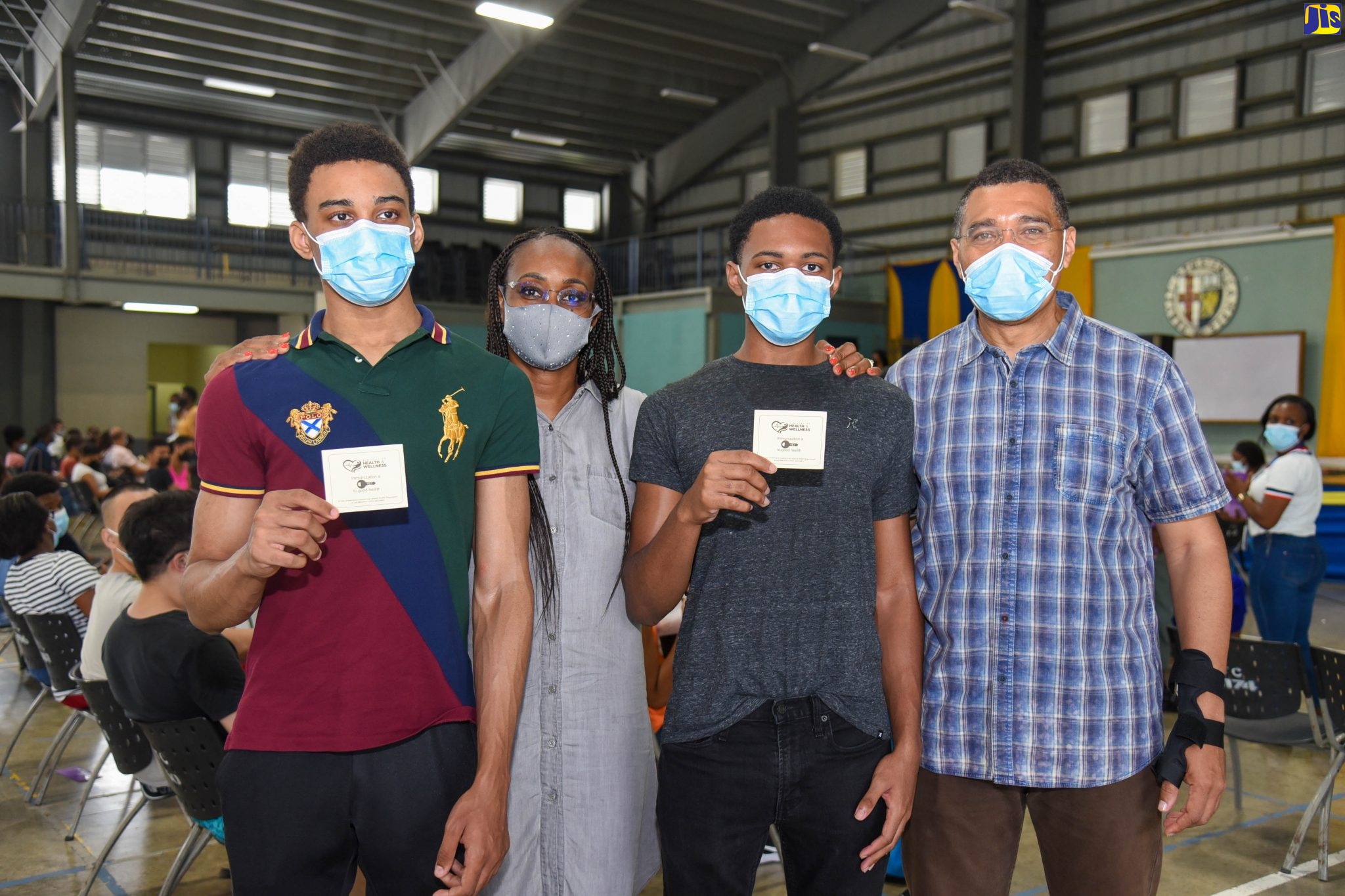 Proud parents, Prime Minister, the Most Hon. Andrew Holness (right), and Deputy Speaker of the House of Representatives, the Most. Hon. Juliet Holness, with sons – Matthew (left) and Adam, who display their coronavirus (COVID-19) vaccination cards which they received after being inoculated with the Pfizer COVID-19 vaccine at Jamaica College on Sunday (August 22). The institution is one of several designated centres islandwide being used for the COVID-19 vaccination blitz for children, 12-18 years, which commenced on Saturday (August 21) and concludes on Tuesday (August 24). Mr. and Mrs. Holness were among the many parents and guardians accompanying youngsters for their vaccinations with the Pfizer brand.