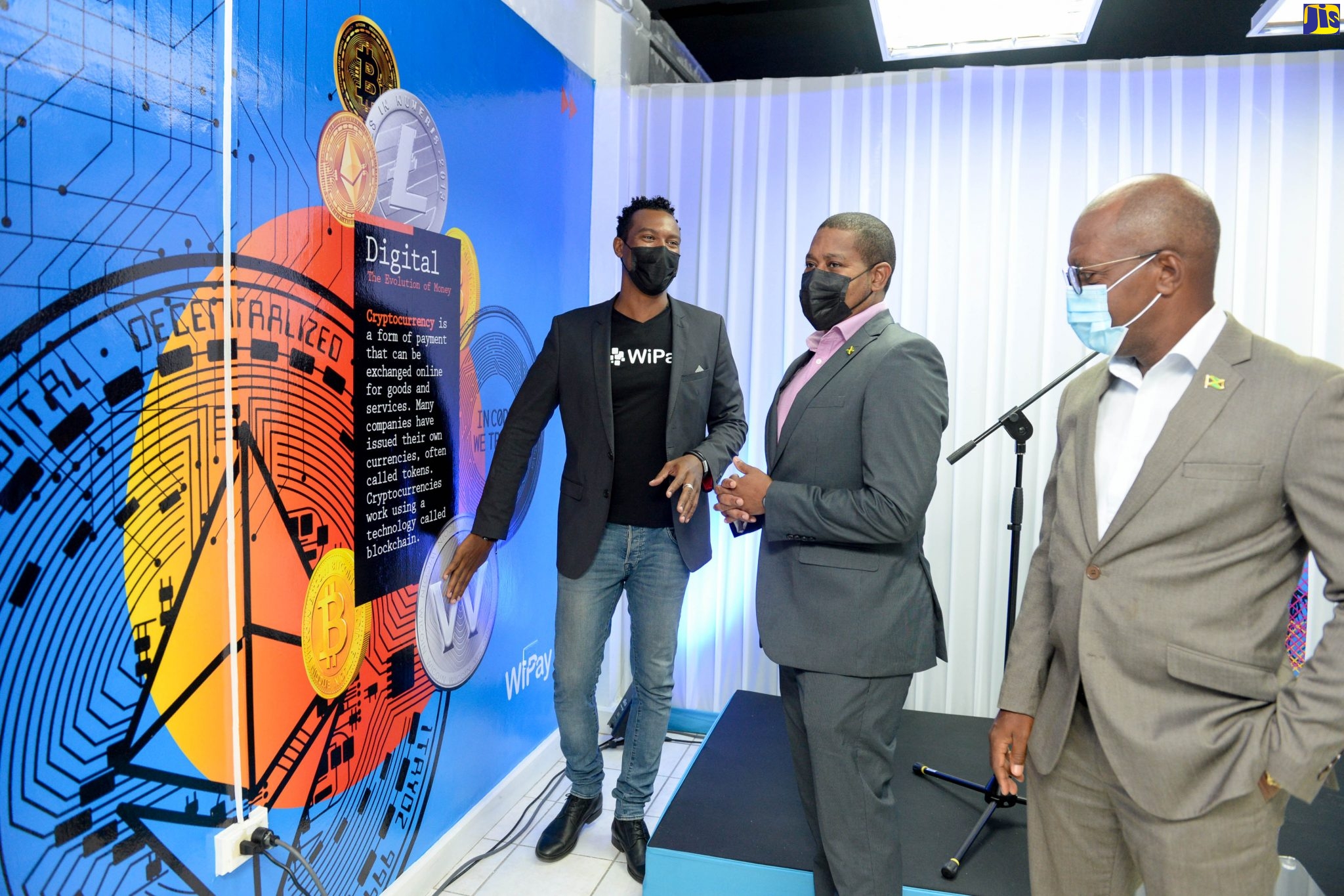Minister of Agriculture and Fisheries, Hon. Floyd Green (centre), discussing digital currency evolution with the online payment facilitator WiPay’s Country Manager for Jamaica, Kibwe McGann (left) and Chairman of WiPay Jamaica, Livingstone Morrison, at the opening ceremony of the company’s new headquarters in New Kingston Thursday (August 26).