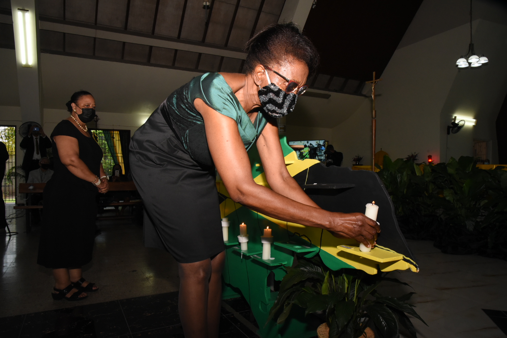 Custos of St. Thomas, Marcia Bennett, representing Governor-General, His Excellency the Most Hon. Sir Patrick Allen, lights a candle in honour of lives lost due to the coronavirus (COVID-19) pandemic during a special virtual ceremony at the St. Theresa Roman Catholic Church in Vineyard Town, St. Andrew, on August 4. The ceremony was hosted by the National Chorale of Jamaica. 

