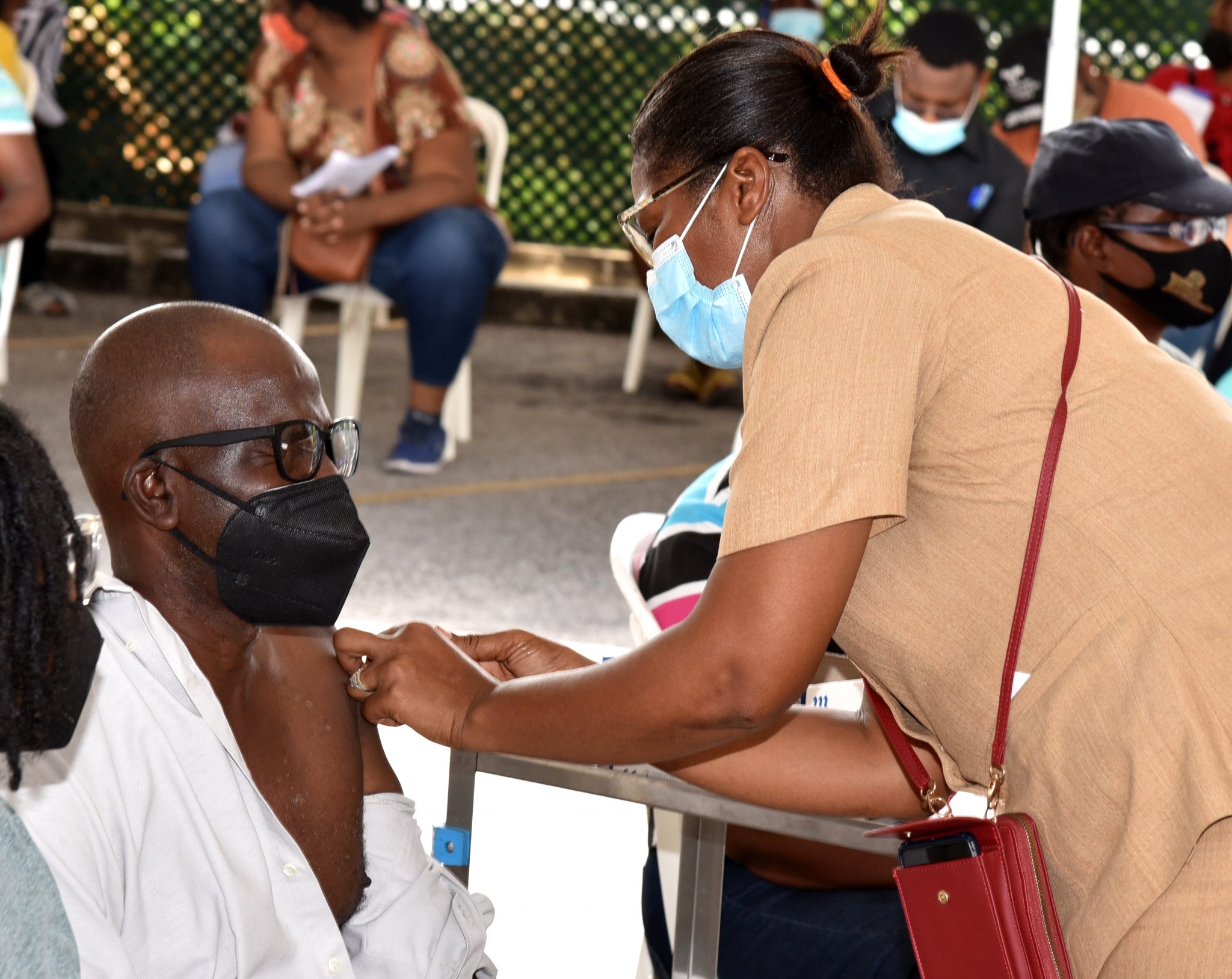 Public Health Nurse, Kingston and St. Andrew Health Department, Loraine Holt (right), administers the AstraZeneca coronavirus (COVID-19) vaccine to Neville Grant during the Ministry of Health and Wellness’s first mobile vaccination drive on August 5 at the Sovereign Centre in St. Andrew.

