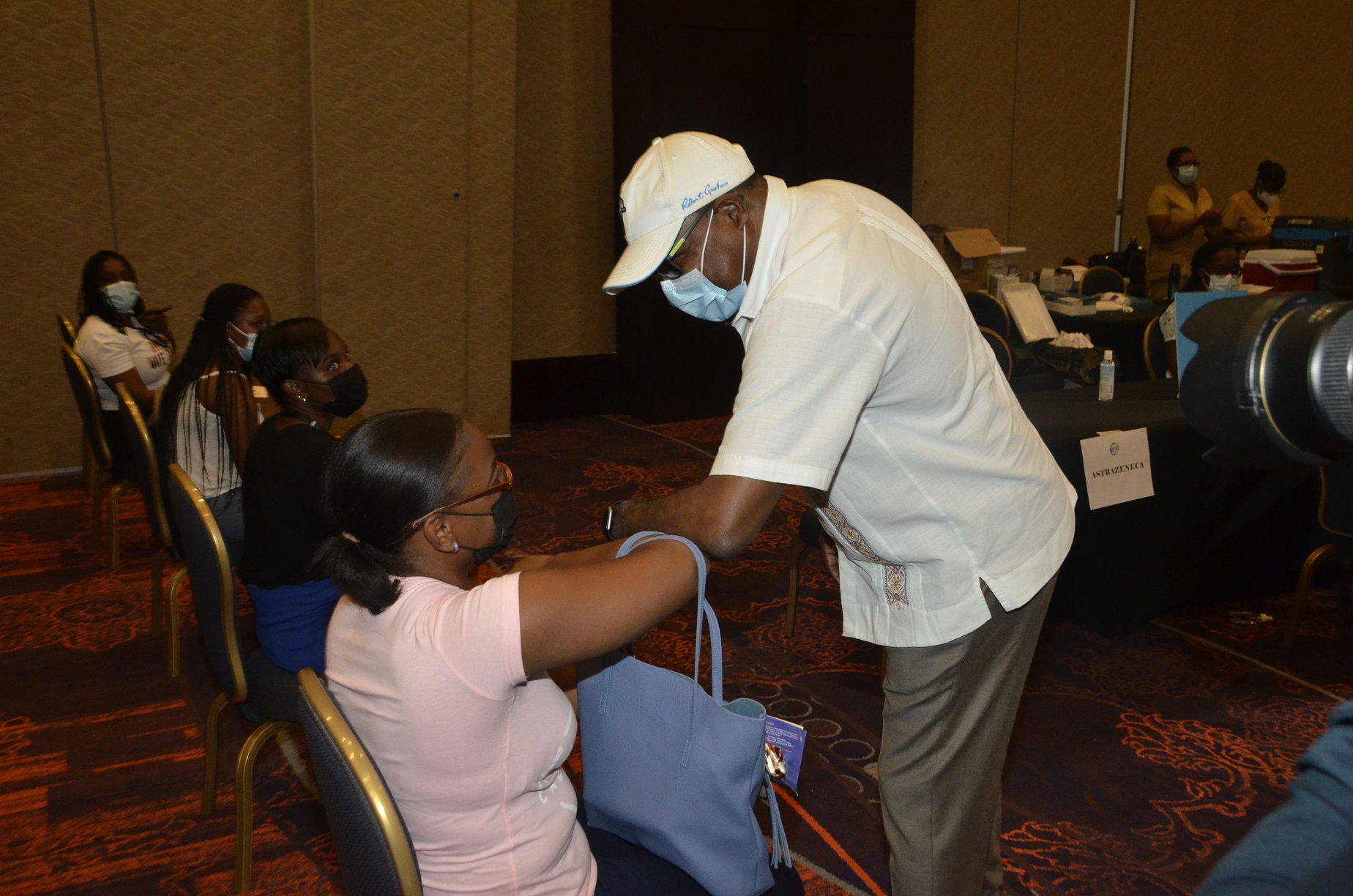 Minister of Tourism, Hon. Edmund Bartlett (right), greeting tourism entrepreneur, Joelle Miller, who is waiting to be vaccinated at the Tourism Vaccination Task Force’s COVID-19 Vaccination Blitz, held at Moon Palace in Ocho Rios, St. Ann, on Friday, September 3. The Minister toured the facilities on the day.  Photo: Okoye Henry

