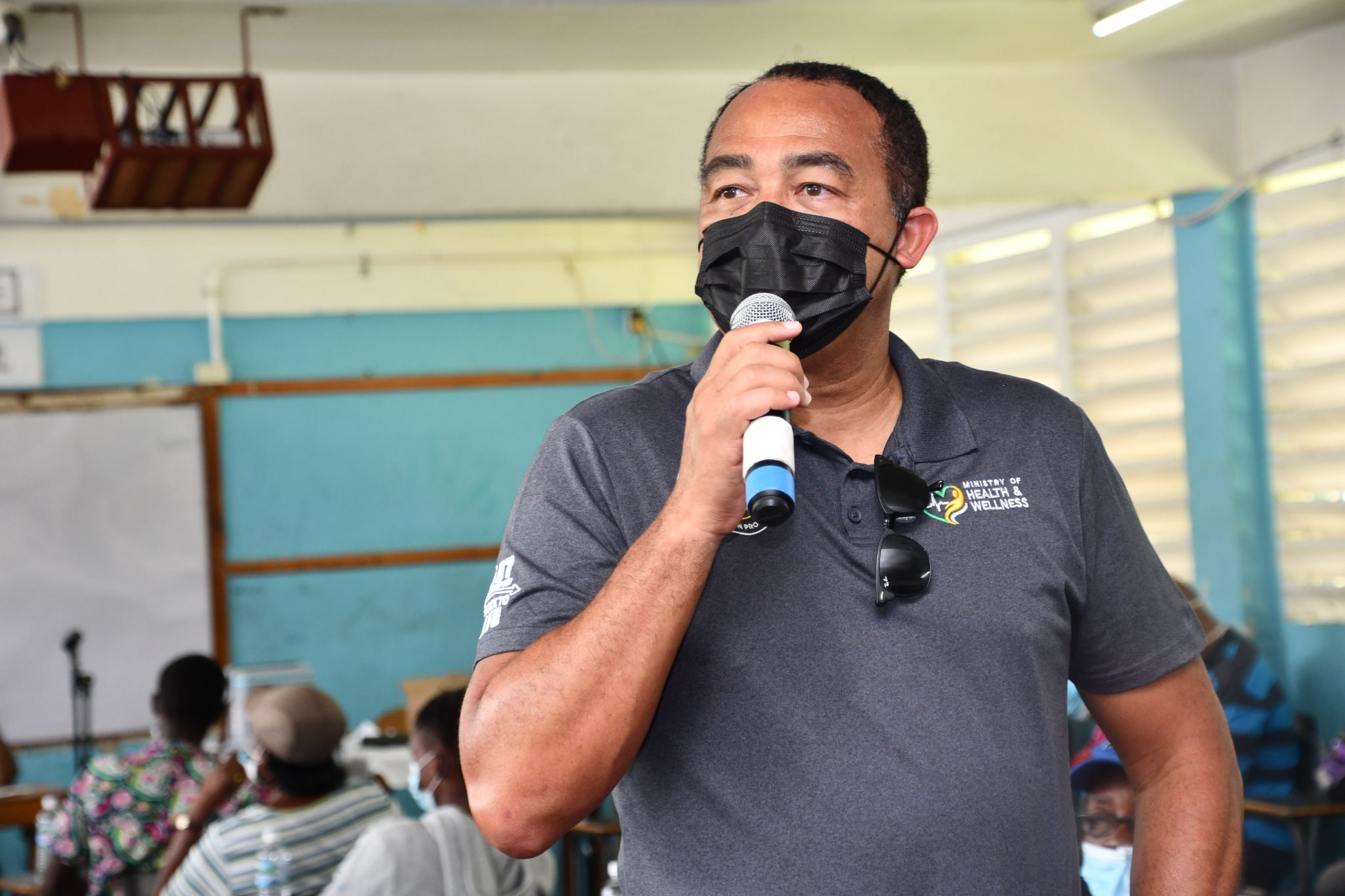 Minister of Health and Wellness, Dr. the Hon. Christopher Tufton, addresses persons waiting to get the coronavirus (COVID-19) vaccine at Grange Hill High School in Westmoreland on Thursday (September 2). The occasion was a sensitisation tour of communities and visits to vaccination sites in the parish by Ministry officials.  


