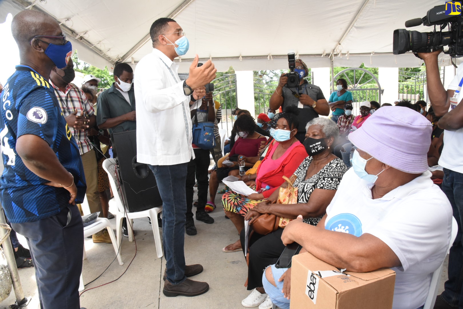 Prime Minister, the Most Hon. Andrew Holness (second left), addressing persons who turned out to receive the coronavirus (COVID-19) vaccine at the Jamaica-China Goodwill Infant School at Olympic Way, West Central St. Andrew, on Friday, September 10.   He was accompanied by Minister of Local Government and Rural Development, Hon. Desmond McKenzie (left).  The visit was part of the Prime Minister’s vaccine mobilisation and public education campaign.