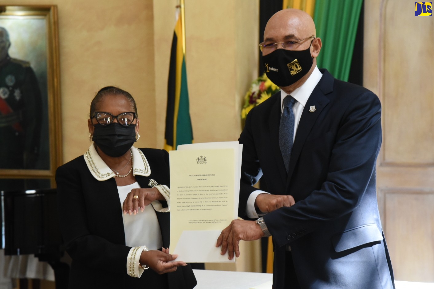 Governor-General, His Excellency the Most Hon. Sir Patrick Allen (right), presents newly appointed Custos Rotulorum for the Parish of St. Catherine, Icylin Golding, with the Instruments of Office during the swearing-in ceremony at King’s House, on Friday (September 24).