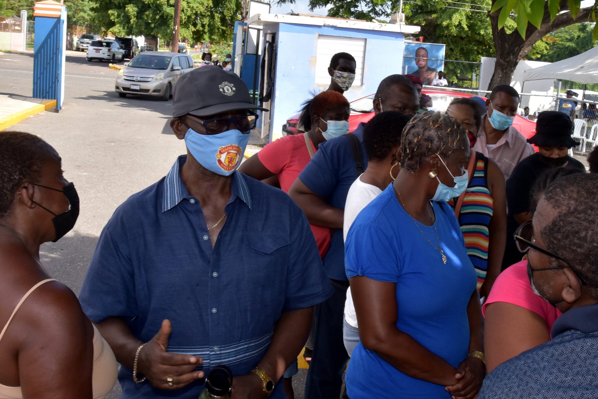 Minister of Local Government and Rural Development and Member of Parliament for Kingston Western,  Hon. Desmond McKenzie (second left), engages with residents who turned out at the coronavirus (COVID-19) vaccination site at the Tivoli Gardens High School in the constituency, on Thursday (September 2).

