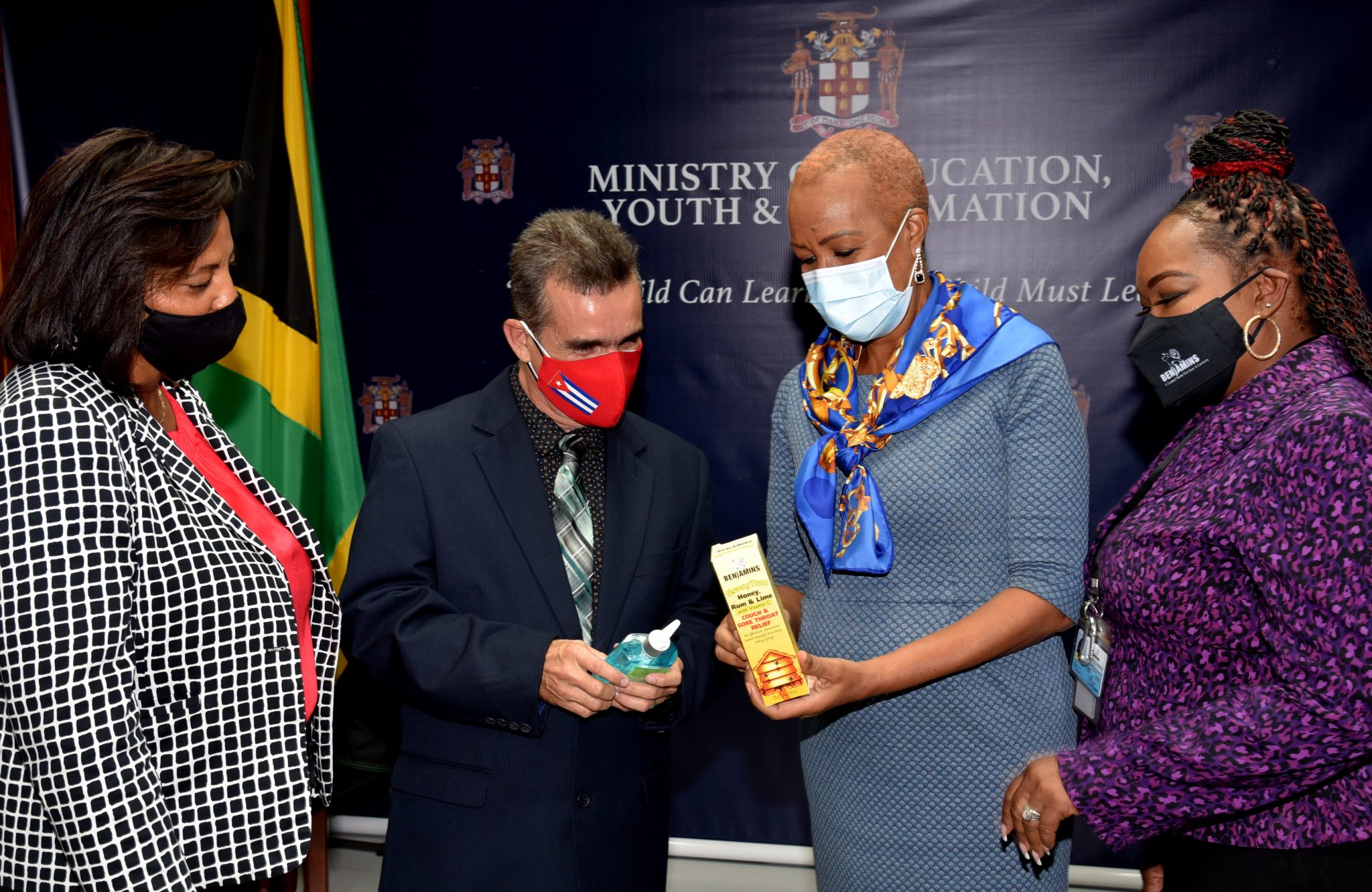 Minister of Education, Youth and Information, Hon. Fayval Williams (second right), looks at  a bottle of cough syrup, which is among pharmaceutical and personal care items contained in care packages, that have been donated for Cuban teachers in Jamaica, by P.A. Benjamin Manufacturing Company Limited. Looking on (from left) are Marketing Manager for Pharmaceuticals and Exports, P.A. Benjamin, Andreen Bennett; Coordinator of the Cuban Educational Brigade in Jamaica, Dr. Reynel Isalgue Isalgué;  and Marketing Manager for Food and Personal Care,  P.A. Benjamin, Lisa Andrade Thompson. The items were handed over at the Ministry’s headquarters in Kingston on Friday (September 24).