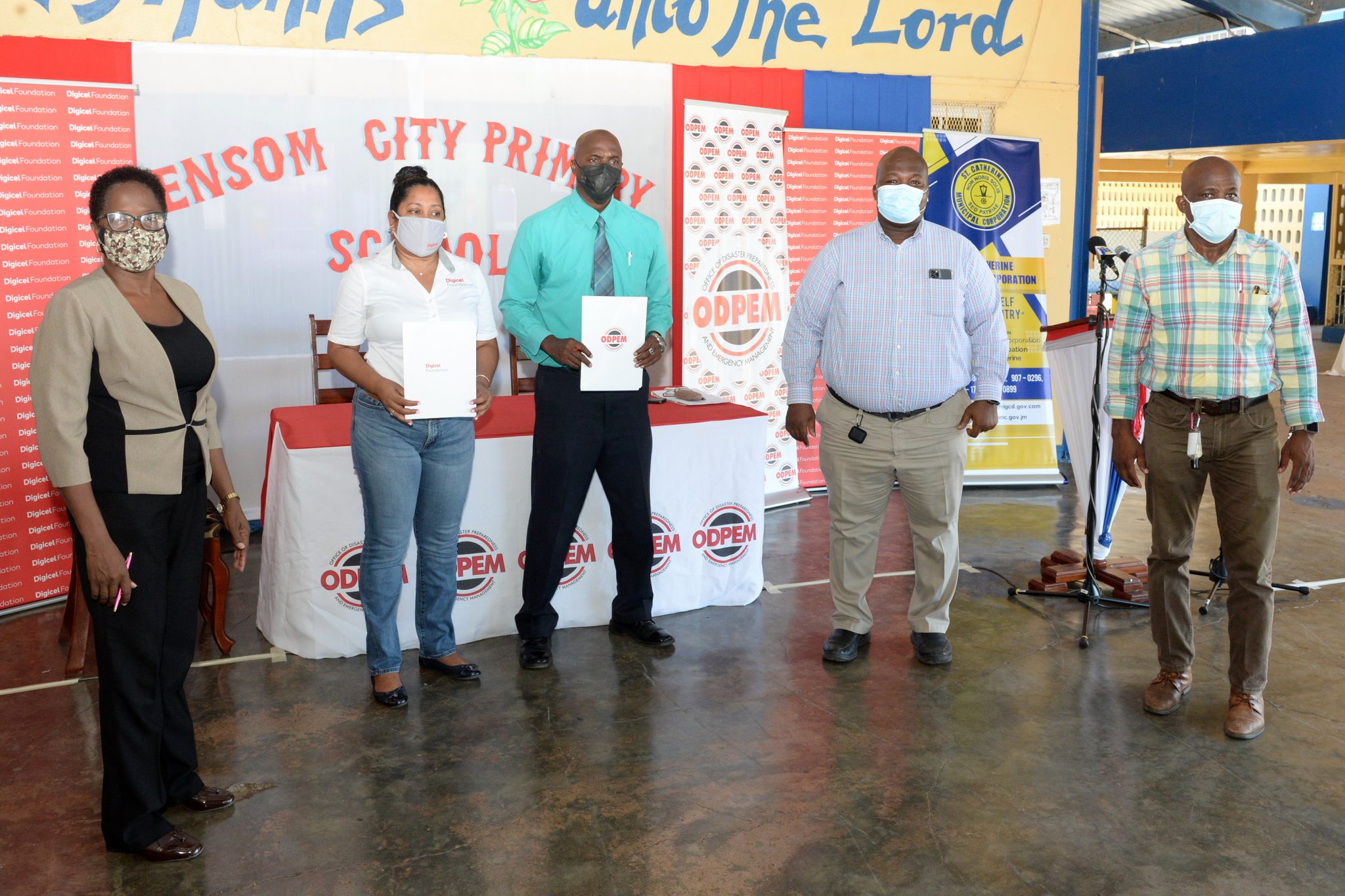 Chief Executive Officer of the Digicel Foundation, Charmaine Daniels  (second left), and  Director-General (Ag) of the Office of Disaster Preparedness and Emergency Management  (ODPEM), Richard Thompson (third left), display the agreement between the two entities to upgrade five schools that are designated as emergency shelters, at a signing ceremony held at the Ensom City Primary School in St. Catherine last Thursday (September 23). Others pictured (from left) are Principal of the Ensom City Primary School, Karlene Collins-Dawkins; Chief Executive Officer of the St. Catherine Municipal Corporation, André Griffiths; and Councillor for the Ensom City Division, George Moodie. Photo: Dave Reid 

