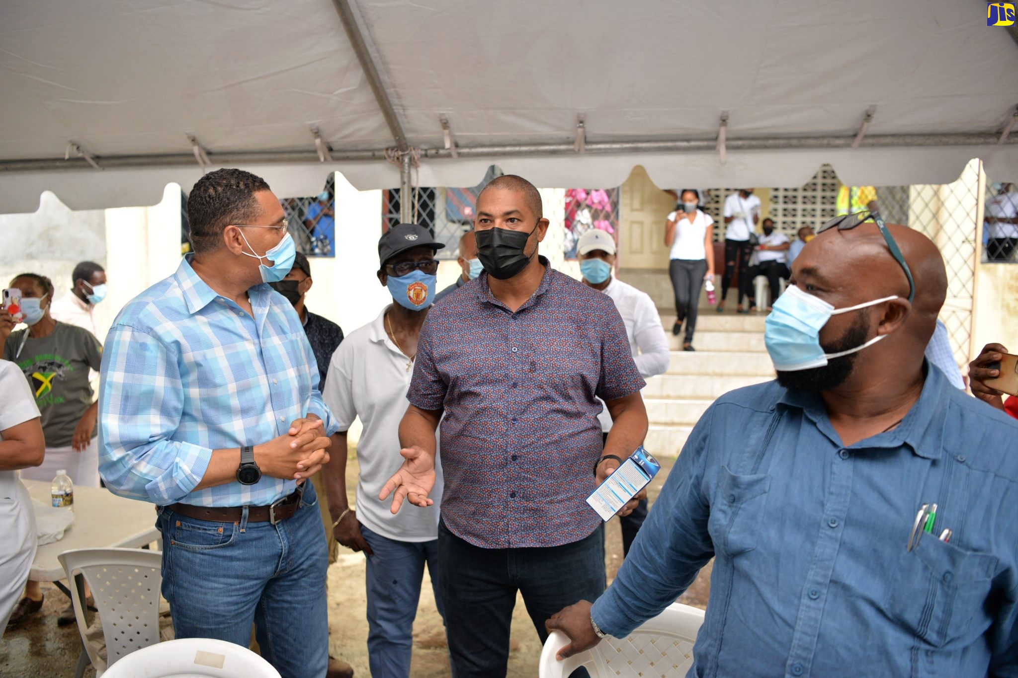 Prime Minister, the Most Hon. Andrew Holness (left), converses with Member of Parliament for North West Manchester, Mikael Phillips, at the Greenvale Community Centre, during a tour of vaccination blitz sites in the parish on Thursday (September 16). In the background (centre) is Minister of Local Government and Rural Development, Hon. Desmond  McKenzie.