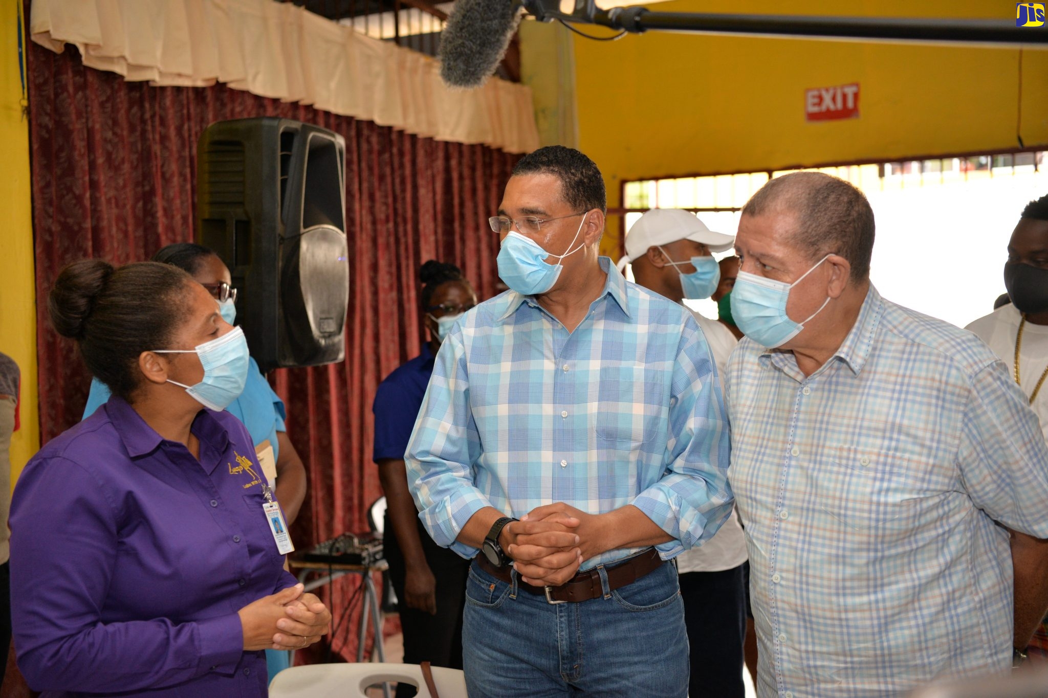 Prime Minister, the Most Hon. Andrew Holness (centre), and Member of Parliament for Manchester North East, Audley Shaw, converse with Dr. Shonette Blair-Walters, during a stop at the vaccination blitz site at Holmwood Technical High School in Manchester on Thursday (September 16).  The Prime Minister visited a number of blitz locations in the parish on the day.