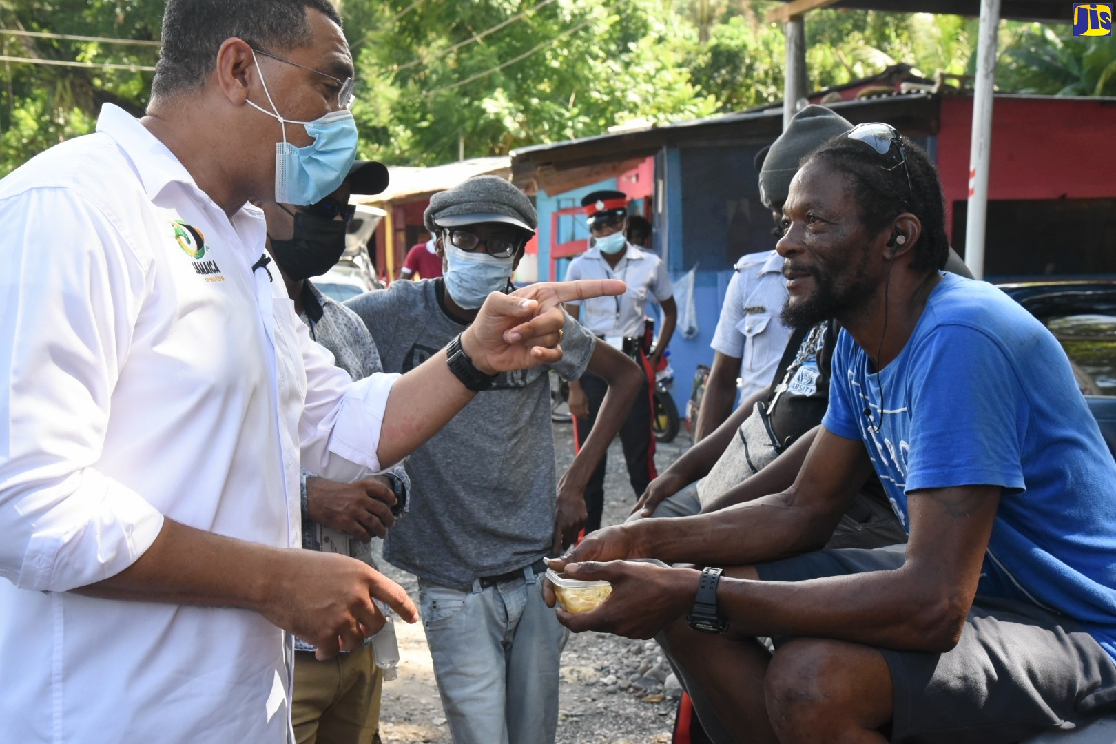 Prime Minister the Most Hon.Andrew Holness (left), engages with a resident of Richmond, St. Mary, while on a vaccination mobilisation tour of sections of the parish on Friday (October 15).