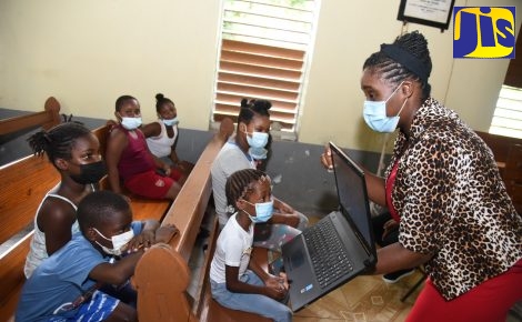 Guidance Counsellor with the Child Protection and Family Services Agency (CPFSA), Kadean Flemings-Gordon (right), shows children something interesting on her laptop computer during a trauma counselling session at the Bath Methodist Chapel in Bath, St. Thomas on Friday (October 22). As part of its response mechanism, the CPFSA is conducting a series of trauma counselling sessions for the children impacted by the recent abductions and violent incidents in Bath, St. Thomas. The sessions are geared at alleviating the high levels of stress, anxiety and fear currently being experienced by the children in the area.