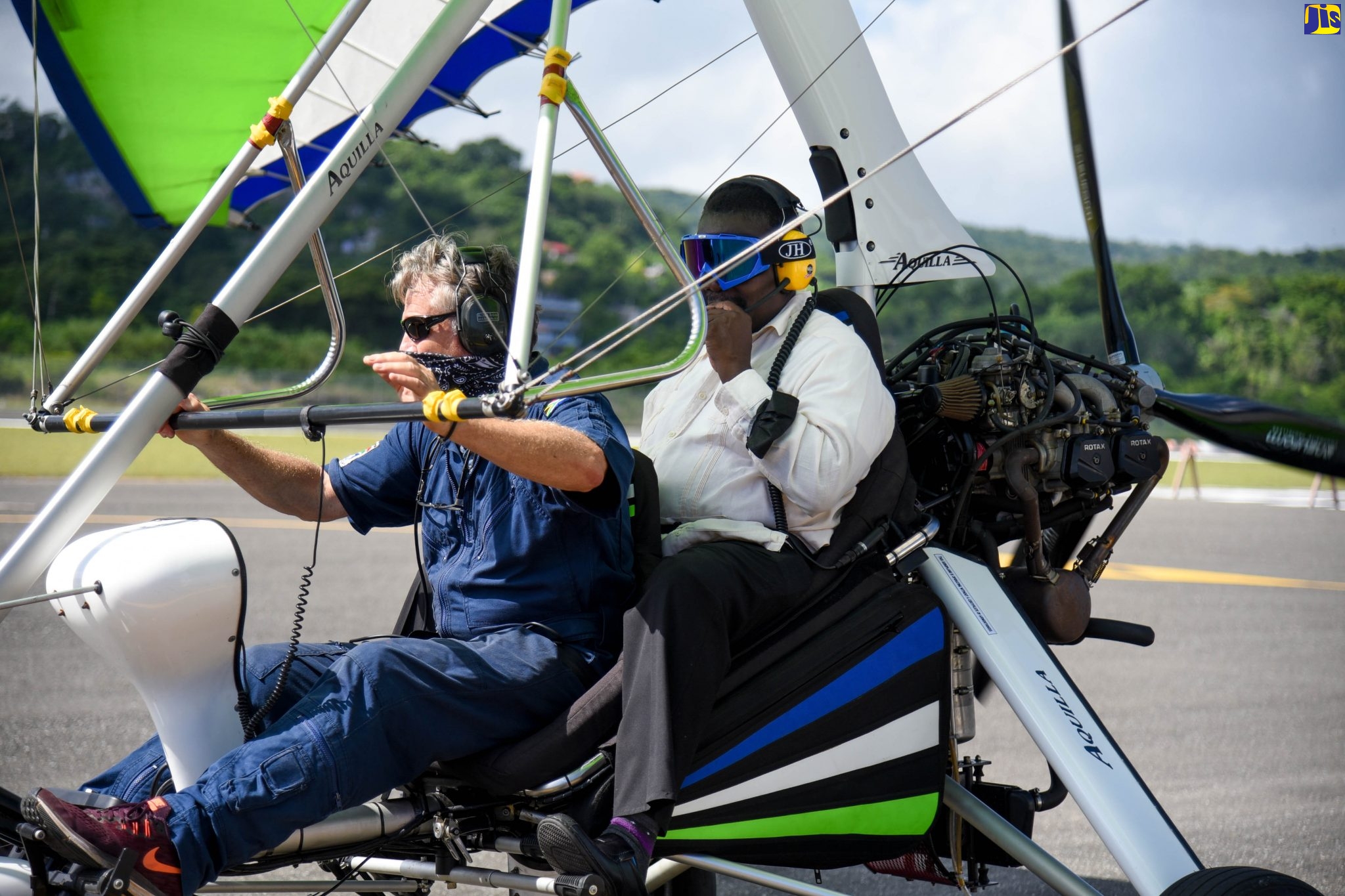Minister of Transport and Mining Hon. Robert Montague (right) is taken on an ultralight flying experience by Chief Pilot of Amber Aviation David Daniel (l) following the entity