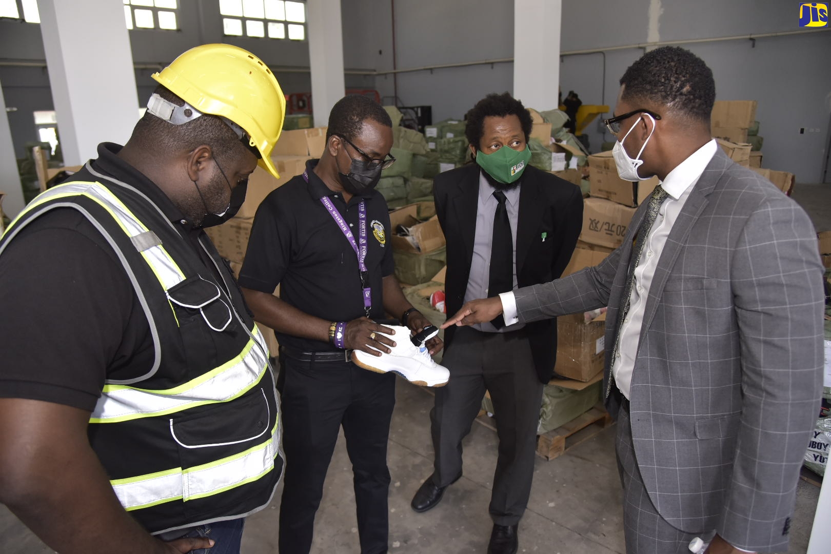 Attorney Mikhail Jackson (right) of the law firm Livingston Alexander and Levy, which represents footwear brands Nike, Puma and others, discusses the fraudulent features of counterfeit sneakers with Director of the Jamaica Customs Agency’s (JCA) Contraband Enforcement Team, Albert Anderson (second left). Also participating in the discussion (from left) are: Supervisor, Contraband Enforcement Team, JCA, Damaly Thomas; and Deputy Director/ Legal Counsel, Jamaica Intellectual Property Office (JIPO), Dr. Marcus Goffe. Occasion was the 
mass destruction of copyright infringing goods at the JCA’s headquarters in Kingston, recently.