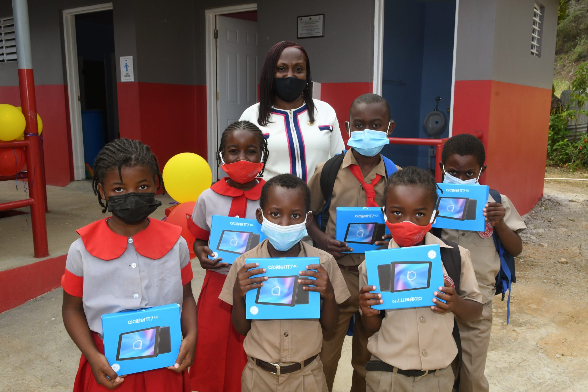 Students of Halls Delight Primary in St. Andrew received tablets under the Government of Jamaica Sanitation in Schools Project. Alson photographed is Principal, Denise Dunchie.
