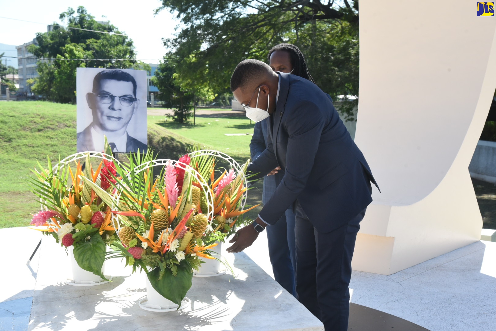 Minister of State in the Ministry of Education, Youth and Information, Hon. Robert Morgan (right), places flowers at the shrine of late former Prime Minister, Sir Donald Sangster, at National Heroes Park in Kingston on Tuesday (October 26). Looking on is State Minister in the Ministry of Culture, Gender, Entertainment and Sport, Hon. Alando Terrelonge.