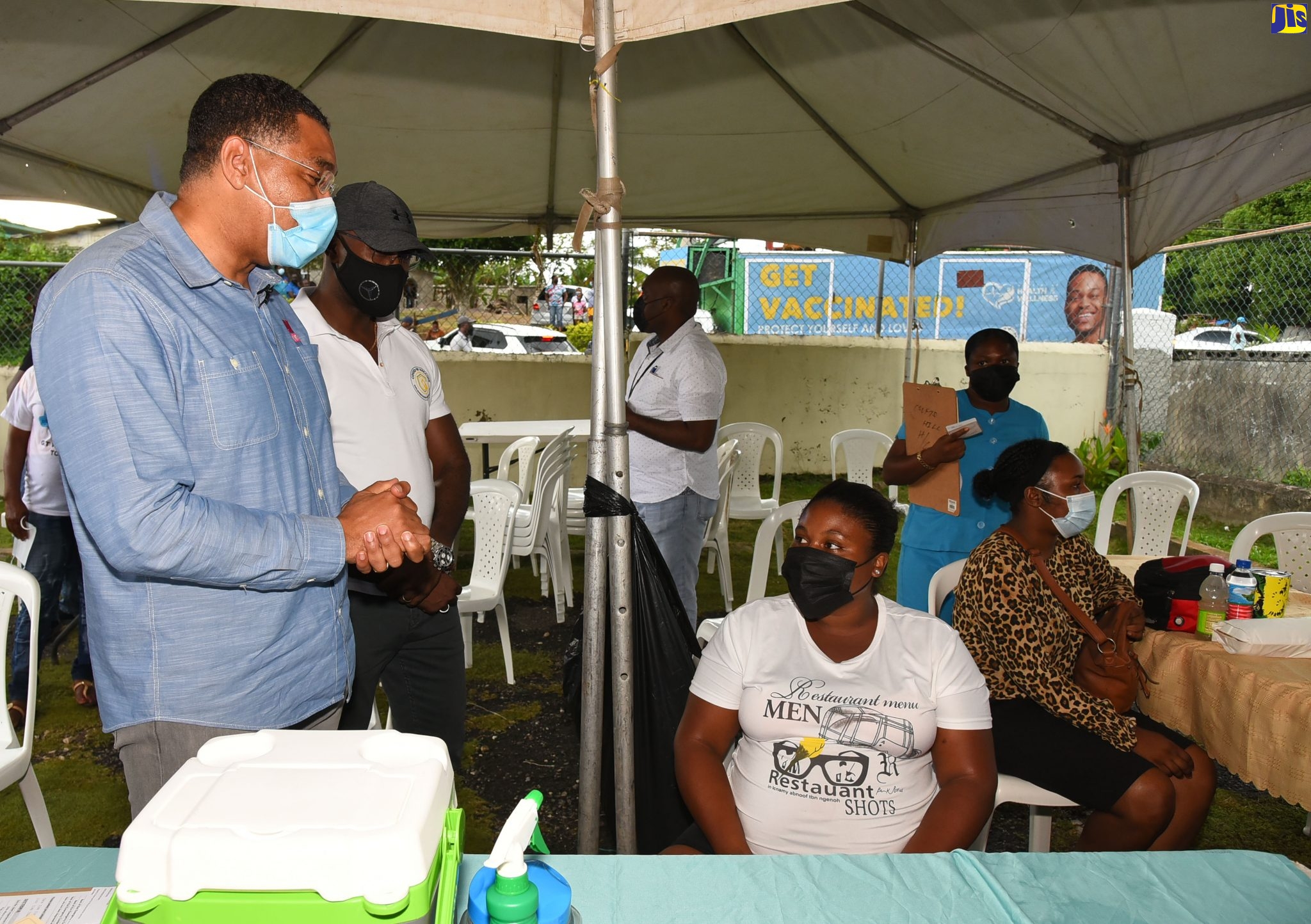 Prime Minister, the Most Hon. Andrew Holness (left), engages with persons gathered at the Croft's Hill Health Centre in Clarendon to receive their vaccine, while on a vaccination mobilisation tour of the parish, recently. Standing next to the Prime Minister is Member of Parliament for Clarendon Northern, Dwight Sibblies.

