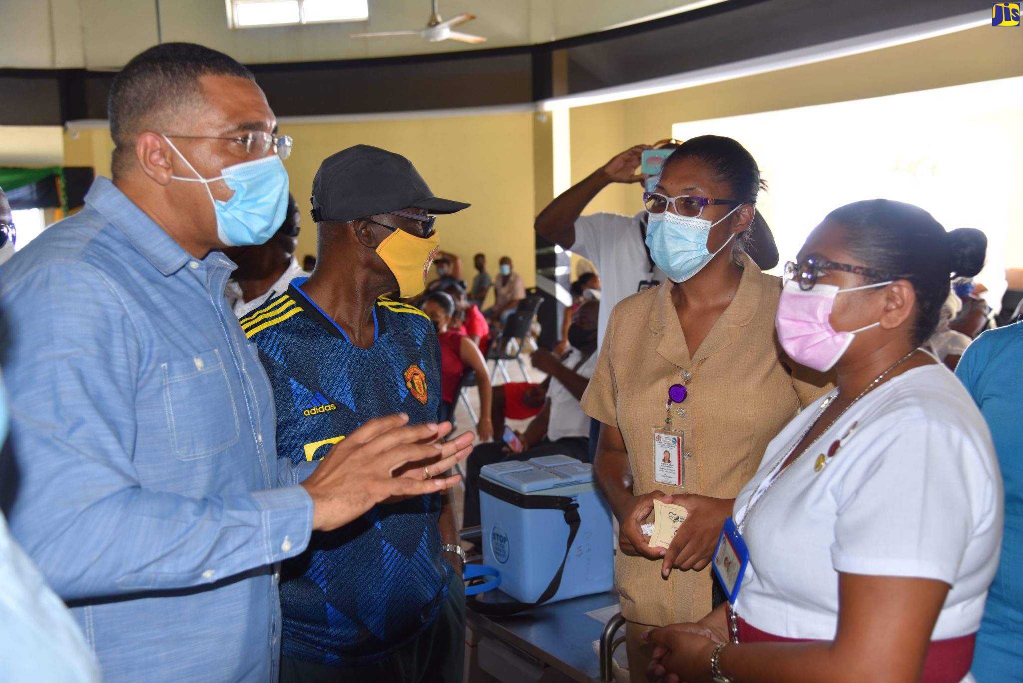 Prime Minister, the Most Hon. Andrew Holness (left), speaks with nurses Bobby-Joe Campbell (right) and Odette Wilson (second right) during a visit to the Port Maria Anglican Church vaccination site in St. Mary, recently. Minister of Local Government and Rural Development, Hon. Desmond McKenzie (second left), accompanied the Prime Minister.