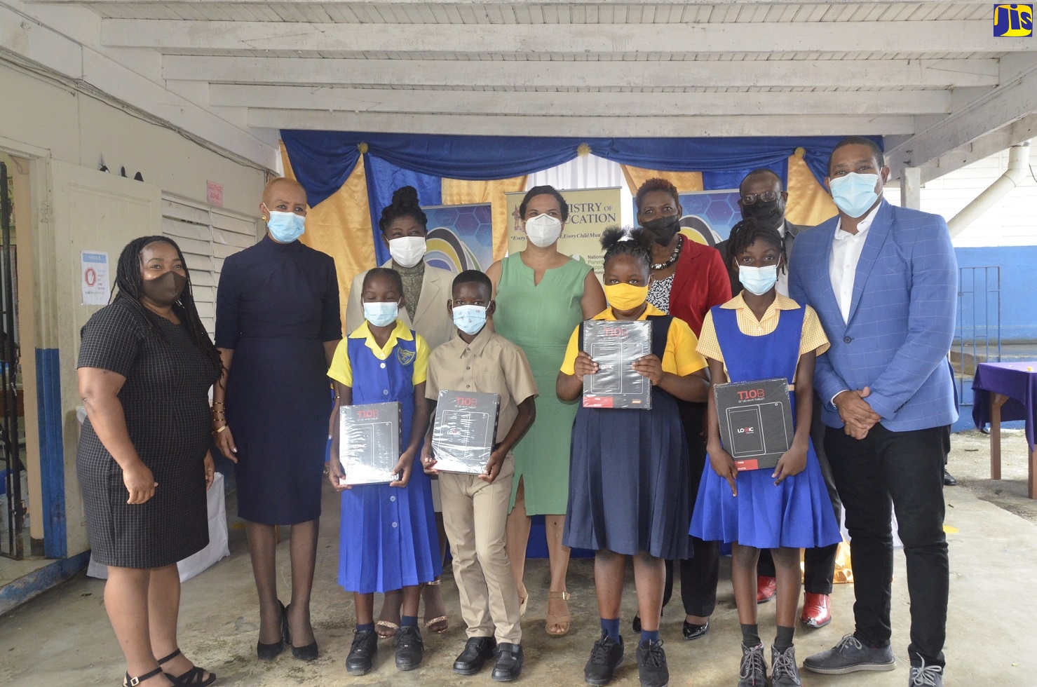 Minister of Education, Youth and Information, Hon. Fayval Williams (second left, back row), is joined by staff and pupils from primary schools in St. Elizabeth South West, during a ceremony at Black River Primary and Infant School for the presentation of tablet computers to grade four students on Friday (November 12), under the Government’s Tablets in Schools Programme. Sharing the moment are Member of Parliament for the constituency, Floyd Green (right, front row), and the Ministry’s Region 5 Director for Regional Education Services, Ottis Brown (right, back row).