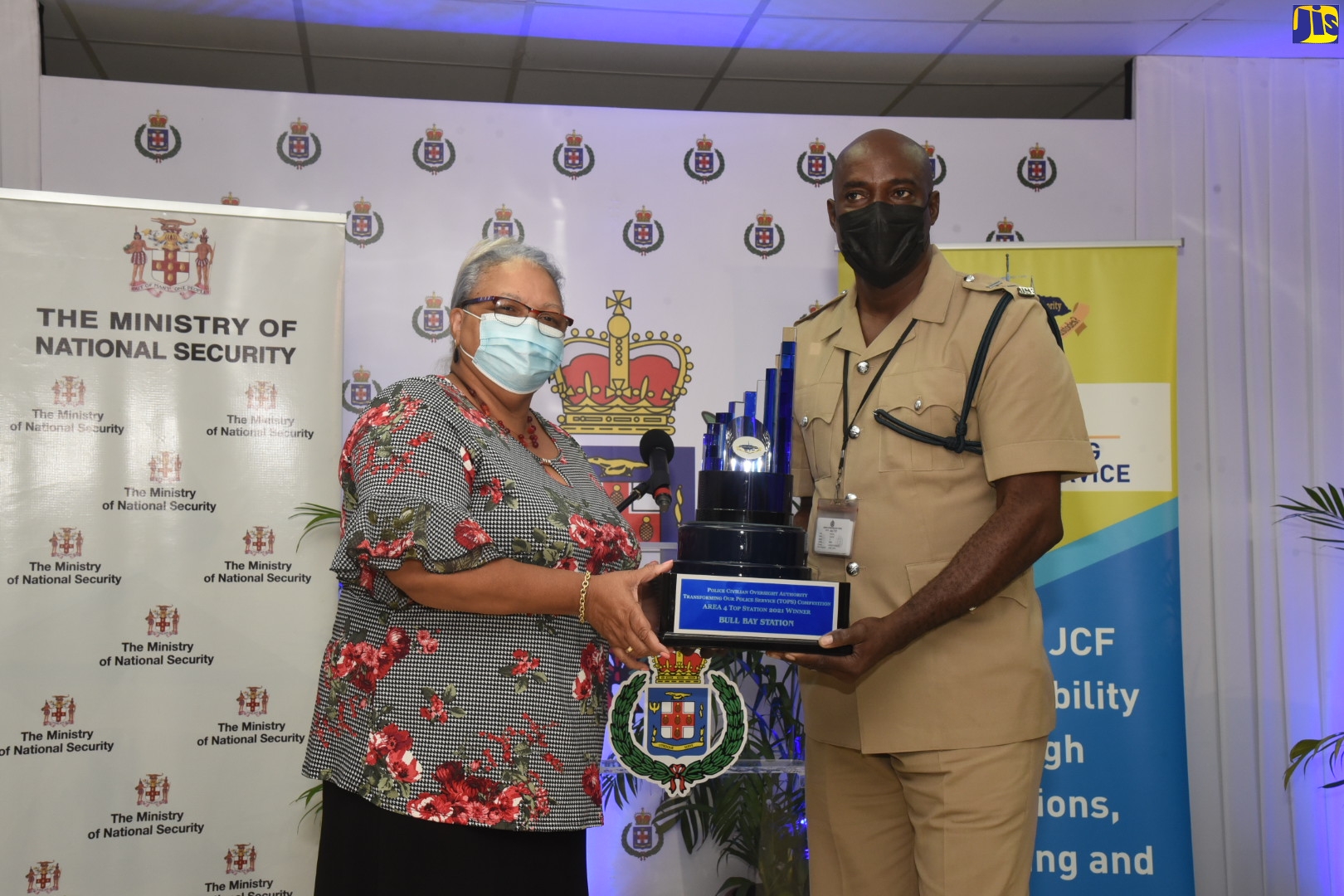 Chairman of the Police Civilian Oversight Authority (PCOA), Jacqueline Hinkson (left), presents Inspector Paul Cummings of the Bull Bay Police Station with the Police Civilian Oversight Authority (PCOA) Transforming Our Police Service (TOPS) award for Top Station in Area Four, during the 2021 awards ceremony held at the Office of the Police Commissioner, St. Andrew, on November 25.