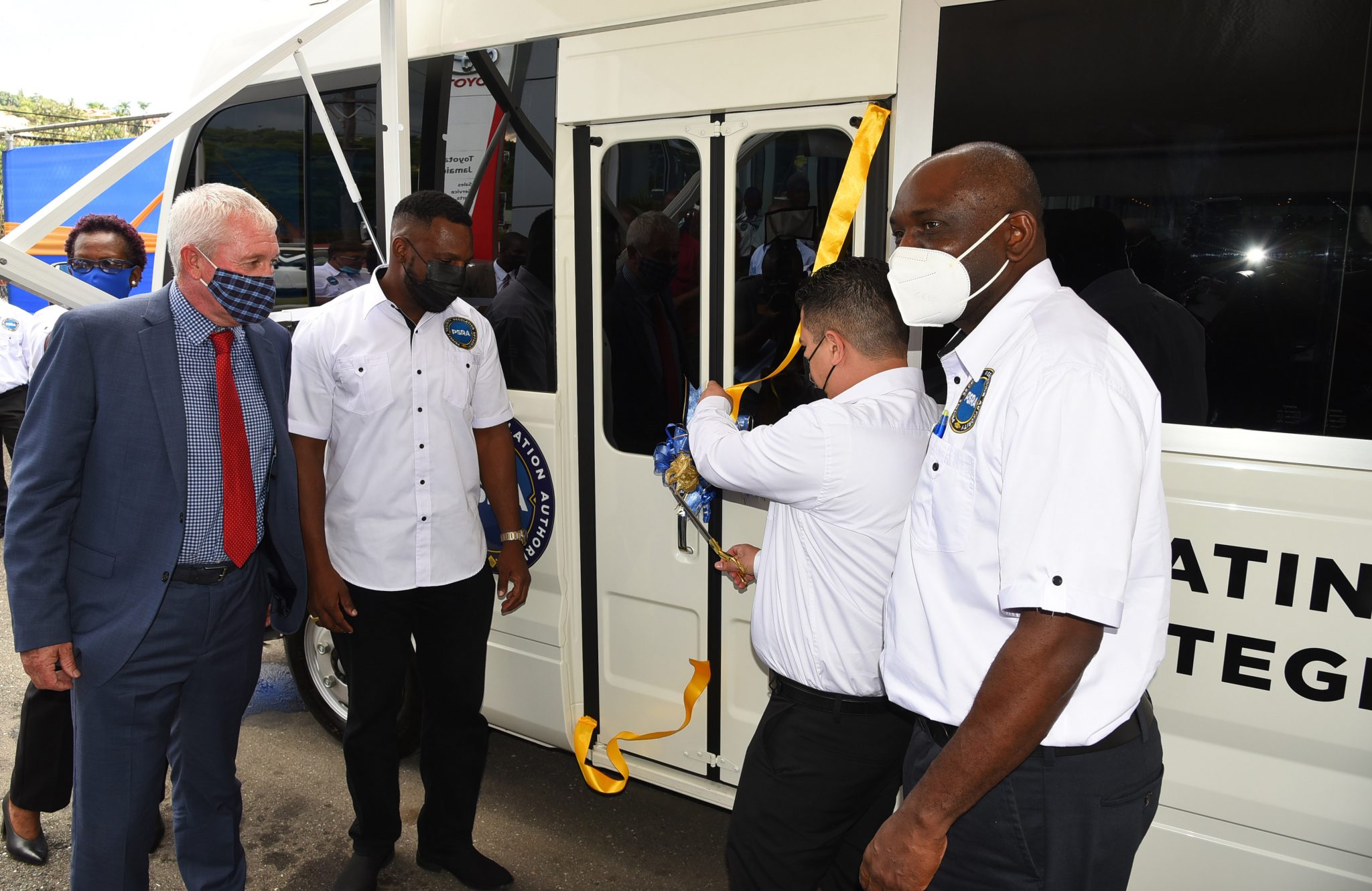 Minister Without Portfolio, Ministry of National Security, Senator the Hon. Matthew Samuda (second right) cuts the ribbon for the Private Security Regulation Authority’s (PSRA) new Mobile Registration Unit MRU handed over by Toyota Jamaica Limited during the official ceremony held on Thursday (November 4) at the company’s offices in St. Andrew. Also pictured are (from left) Managing Director, Toyota Jamaica Limited, Thomas Connor; Executive Director, PSRA, Rick Harris; and Permanent Secretary in the Ministry, Courtney Williams. The event also featured the launch of the PSRA’s online licence renewal portal. Photo: R. Fraser 


