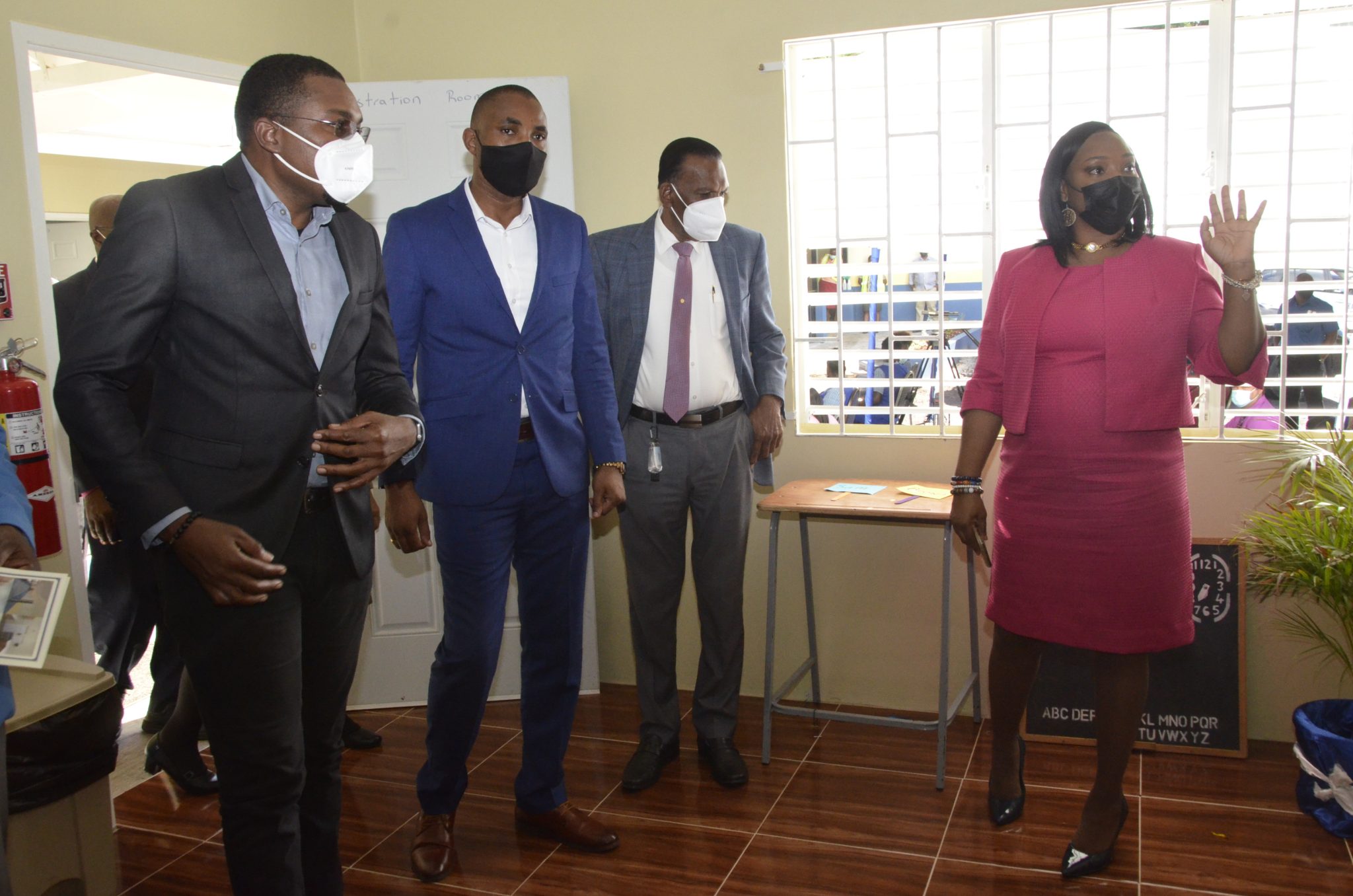 Minister of State in the Ministry of Education, Youth and Information, Hon. Robert Nesta Morgan (left); Chairman of the Board at CHASE Fund, Omar Frith (second left) and Chief Executive Officer of the CHASE Fund, Billy Heaven, are led on a  tour of a section of the Bethlehem Moravian College Early Childhood Centre of Excellence in Malvern, St. Elizabeth, by Acting Head of the Early Childhood Department at the Bethlehem Moravian College, Kade-Ann Daley-Salmon, at the official opening on  Monday (December 6).