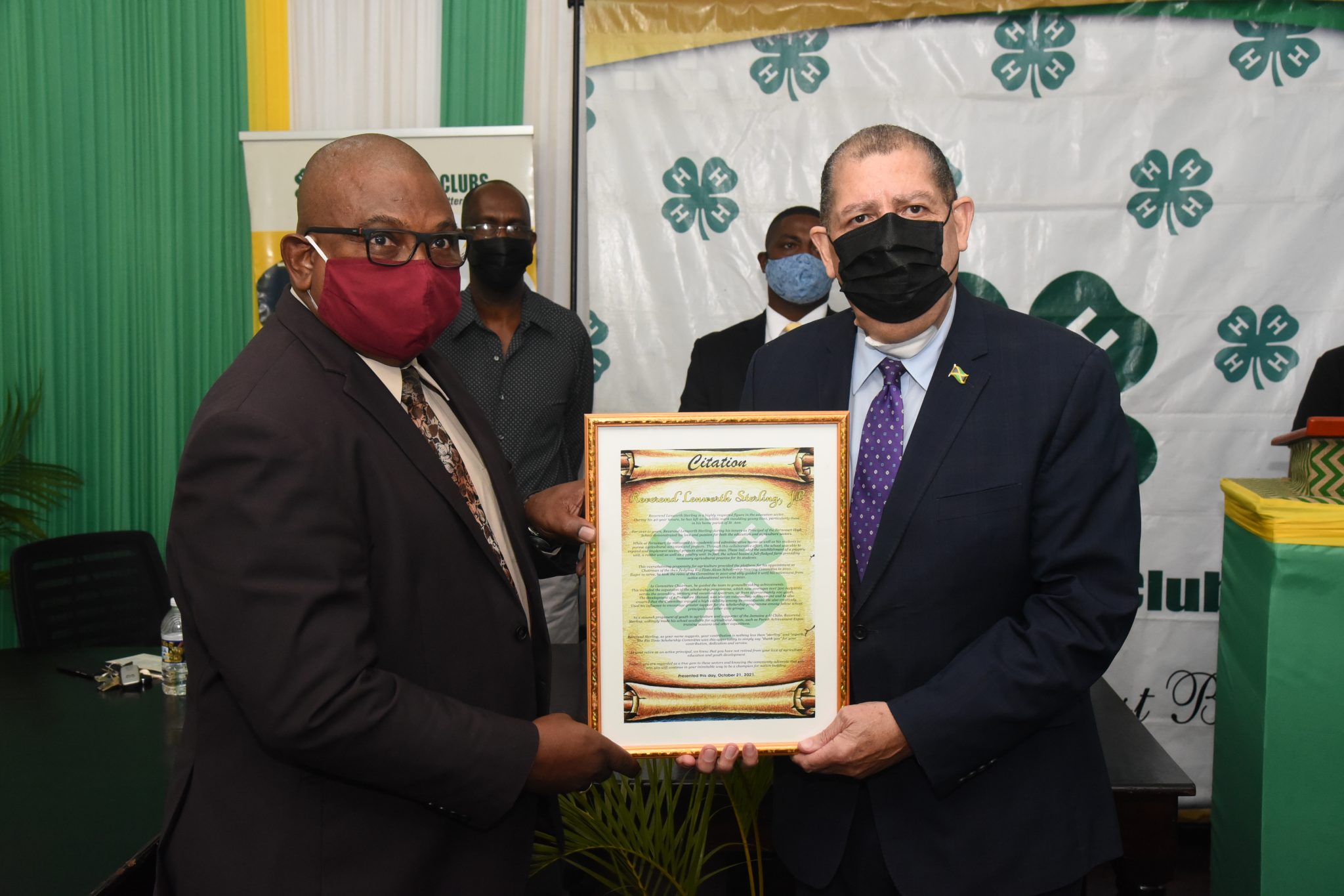 Minister with responsibility for Agriculture and Fisheries Hon. Audley Shaw (right), presents retired Rio Tinto Alcan Legacy Scholarship Steering Committee Chairman Rev. Lenworth Sterling, with a citation from that body and the Jamaica 4-H Clubs, honouring him for unstinting service to agriculture and education. The presentation was made during a semi-virtual ceremony at the Jamaica 4-H Clubs in Kingston. Sharing the moment are: Jamaica 4-H Clubs Executive Director Dr. Ronald Blake (second left); and current Committee Chairman and Principal of Holmwood Technical High School in Manchester, Hidran McKulsky.  Photo: Michael Sloley 

