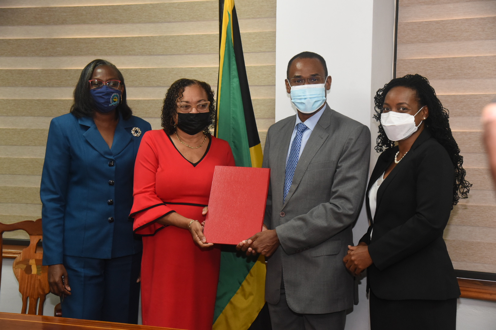 Minister of Finance and the Public Service Dr. the Hon Nigel Clarke (second right), and Jamaica Confederation of Trade Unions (JCTU) President Helene Davis Whyte (second left), display the signed the 2021/22 Heads of Agreement for wage increases for public sector workers represented by JCTU affiliates. Others (from left) are Financial Secretary in the Ministry Darlene Morrison, and State Minister, Hon. Marsha Smith. Photo: Michael Sloley 

