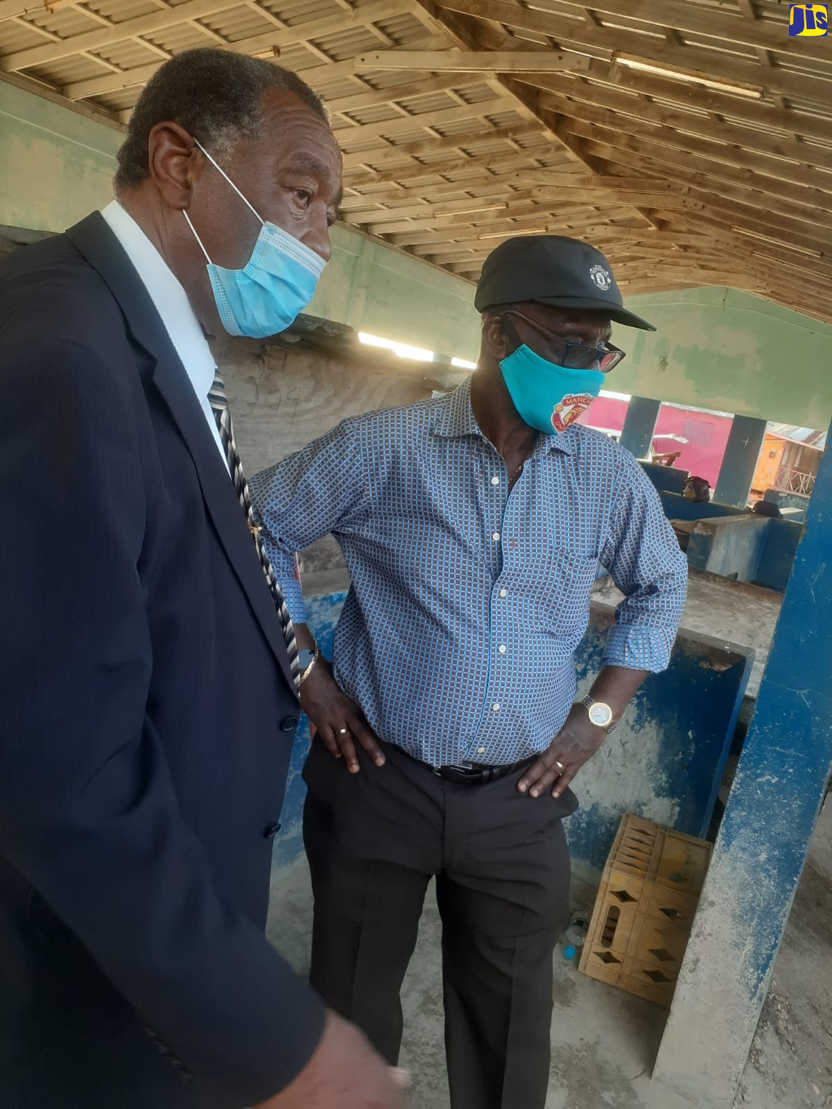 Minister of Local Government and Rural Development, Hon. Desmond McKenzie (right)  converses with Mayor of Savanna-la-Mar, Councillor Bertel Moore, during a tour of the Savanna-la-Mar Market in Westmoreland on Thursday (December 9).