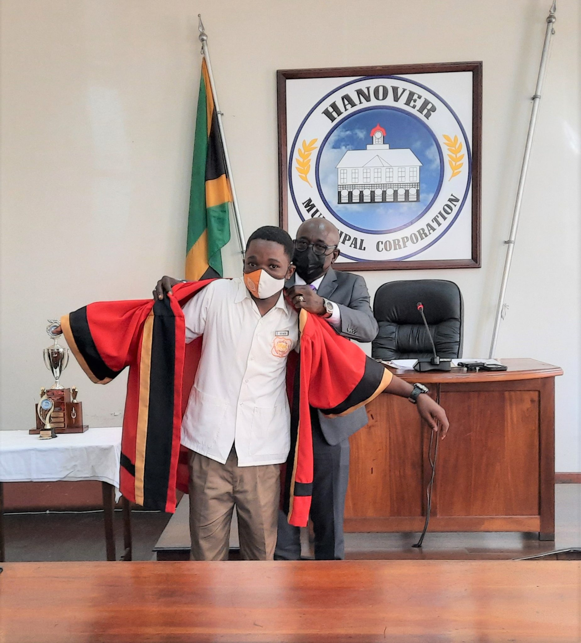 Lucea’s 2021 Youth Mayor, Timothy Kent (left), is symbolically installed into office by Chairman of the Hanover Municipal Corporation (HMC), and Mayor of Lucea, Councillor Sheridan Samuels. The robing and awards presentation ceremony for this year’s competition took place during the recent monthly meeting of the HMC.

