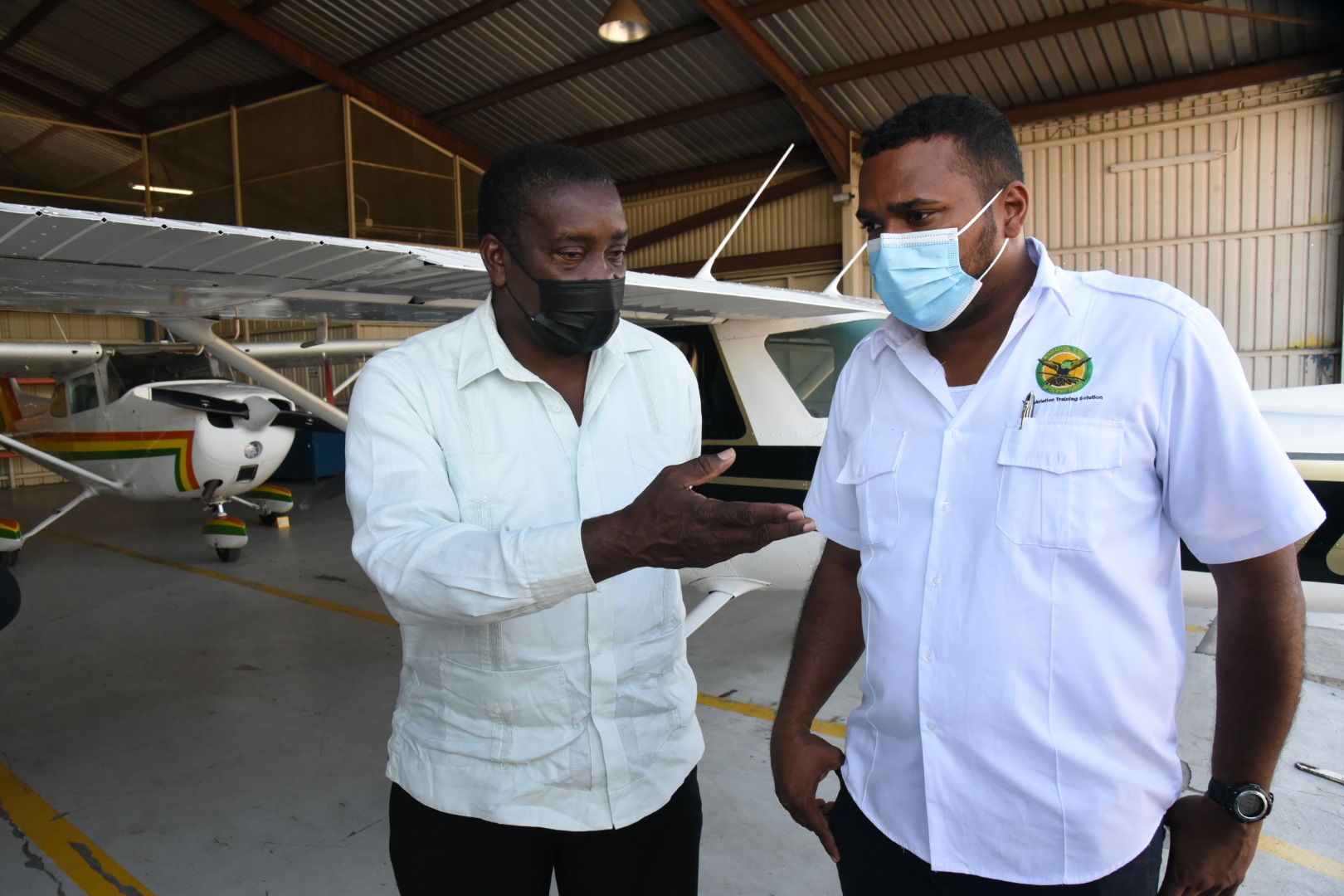 Minister of Transport and Mining Hon. Robert Montague (left), in conversation with Director of the Tinson Pen-based Aeronautical School of the West Indies (ASWI) Christopher Gooding, in St. Andrew, on Wednesday (December 29).  Photo: Michael Sloley

