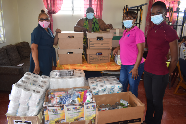 NWC team members Sharmaine Samuels (left) and Blondel Lawrence (second right) hand over care packages and other supplies to home matron Lorna Gordon (back) and Dadrian Forbes (right), guidance counsellor at Garland Hall Memorial Children’s Home in Anchovy, St. James. 

