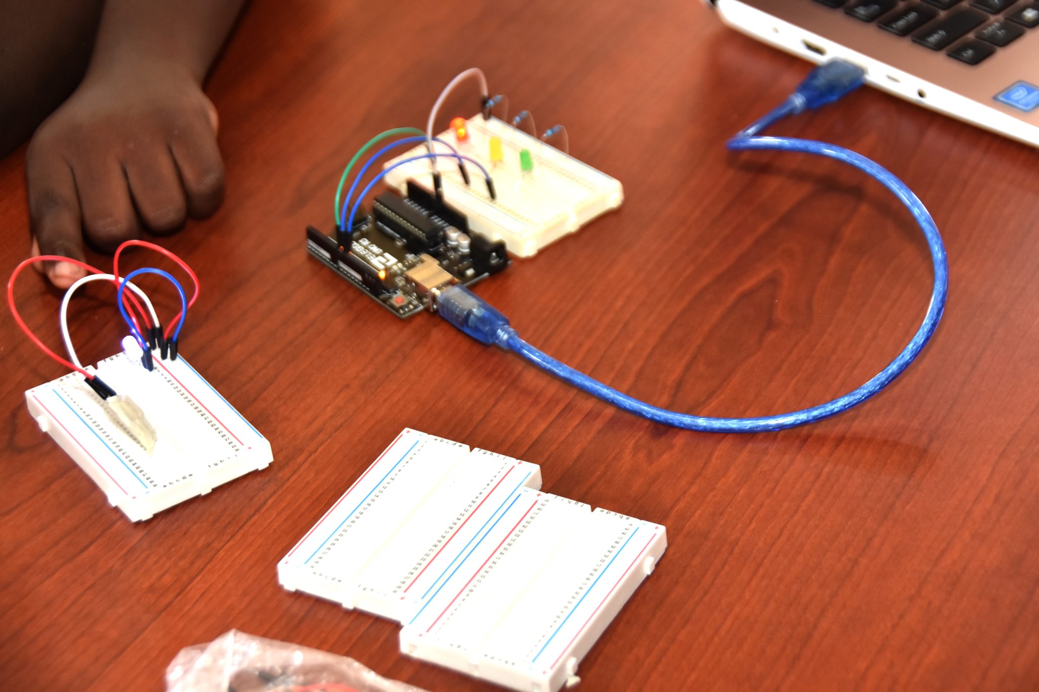  A participant in the Ministry of Education, Youth, and Information's robotics workshop, lights up a miniature set of traffic lights. 
