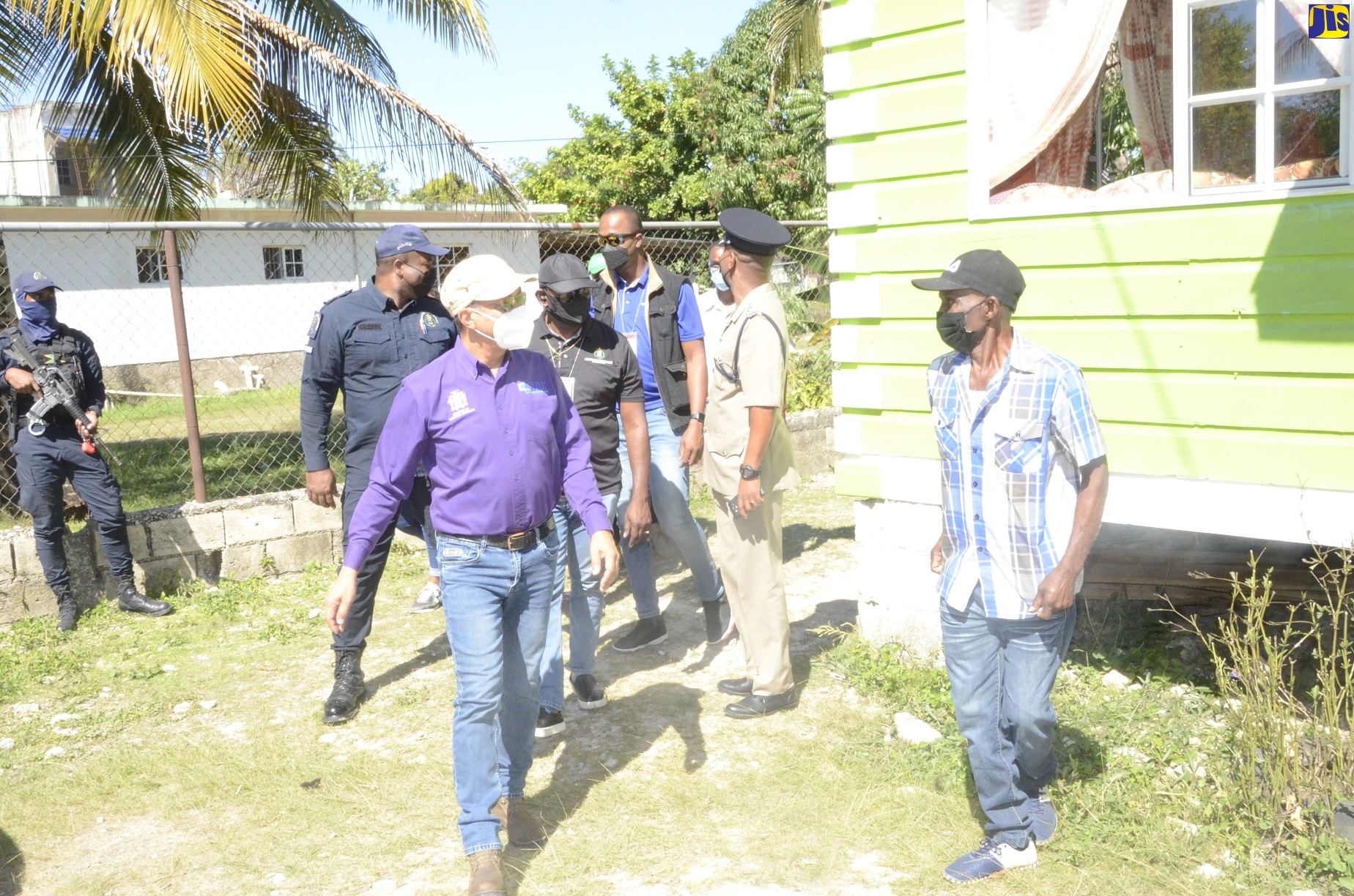 Deputy Prime Minister and Minister of National Security, Hon. Dr. Horace Chang (left), visits premises in the Carawina District in Petersfield, Westmoreland, on Thursday, January 6, where siblings Dervin Jones and Sheldon Jones lost their lives at the hands of gunmen on Tuesday (January 4).